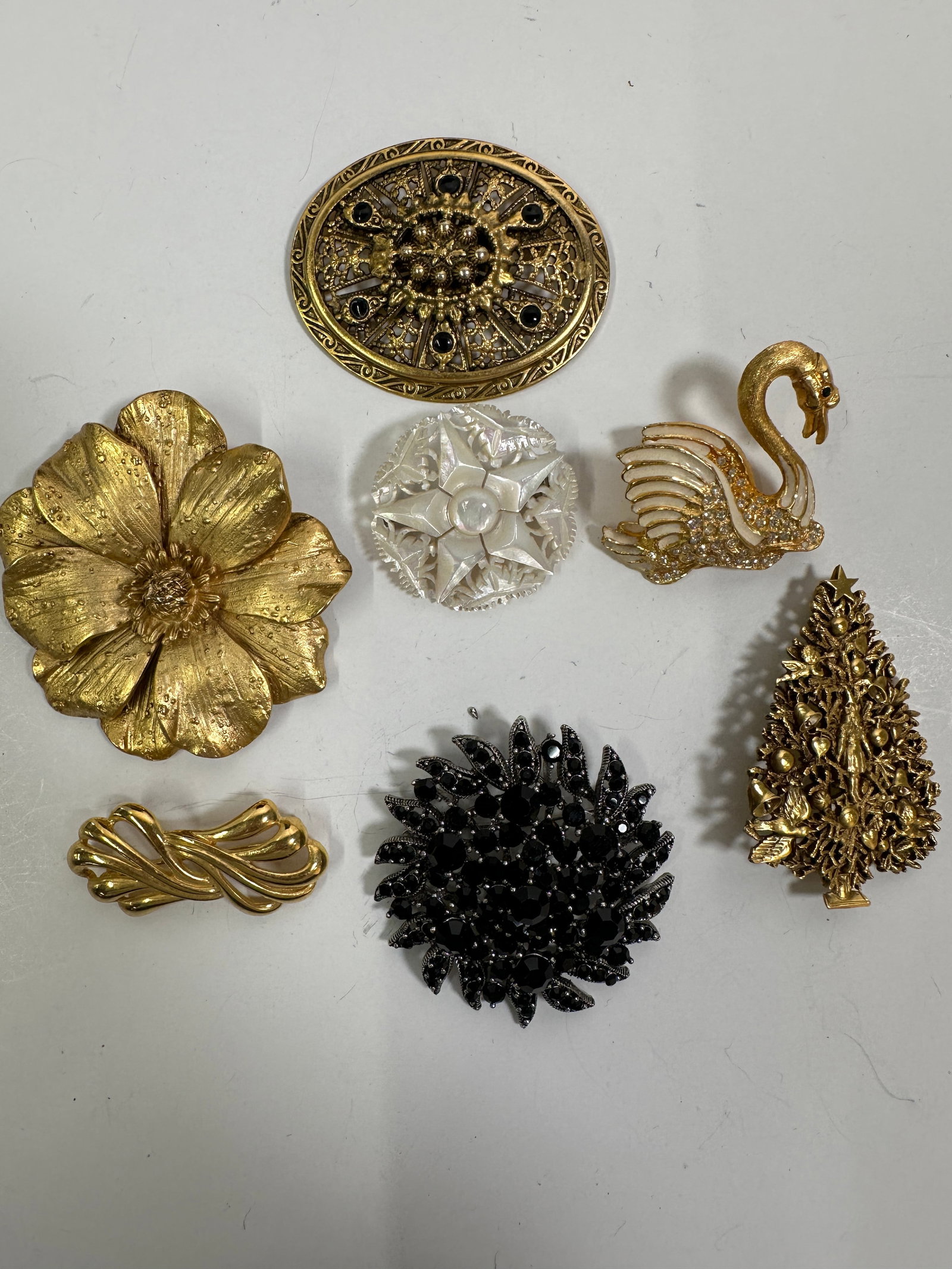 Collection of Seven Costume Brooches: A collection of seven costume brooches, various styles and materials. The largest brooch measures approximately 2.25 inches. Total weight: 4.5 oz.