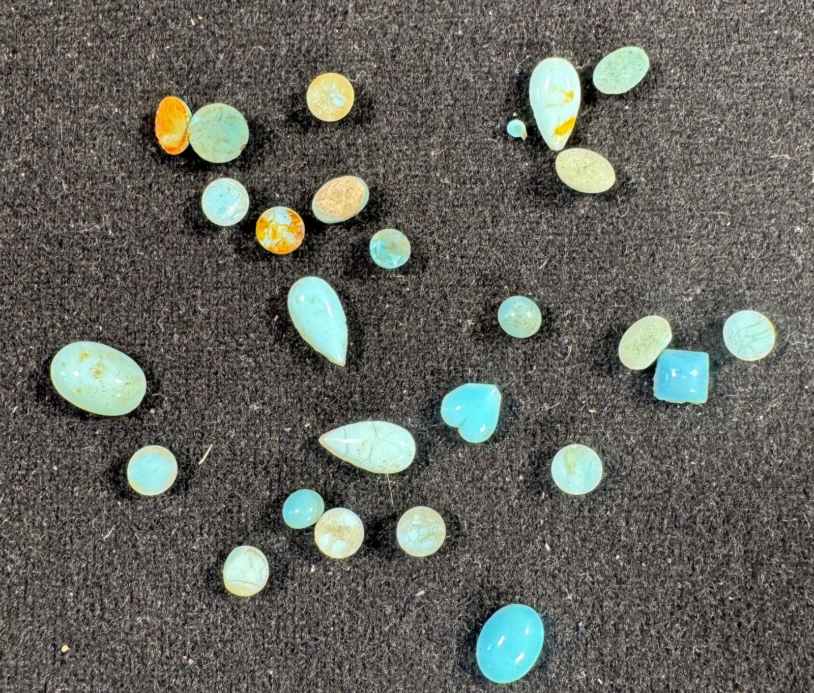 Turquoise Cabochon Loose Stone Lot: A collection of loose turquoise cabochons in various shapes and sizes. Includes oval, round, heart, and other freeform cuts. Colors range from light blue to greenish-blue with some stones showing