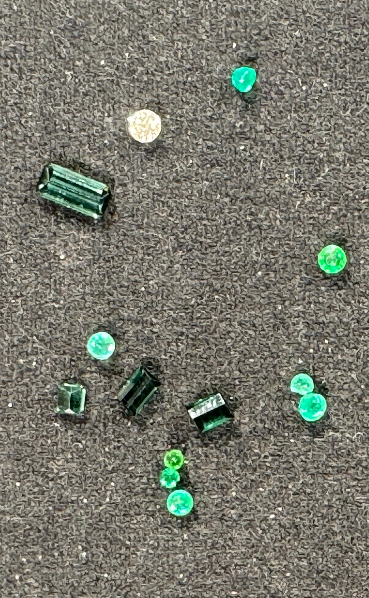 Loose Emeralds and Diamond: Collection of loose emeralds in various cuts and sizes, along with a single small diamond. Emeralds display a rich green color. Sold as is.