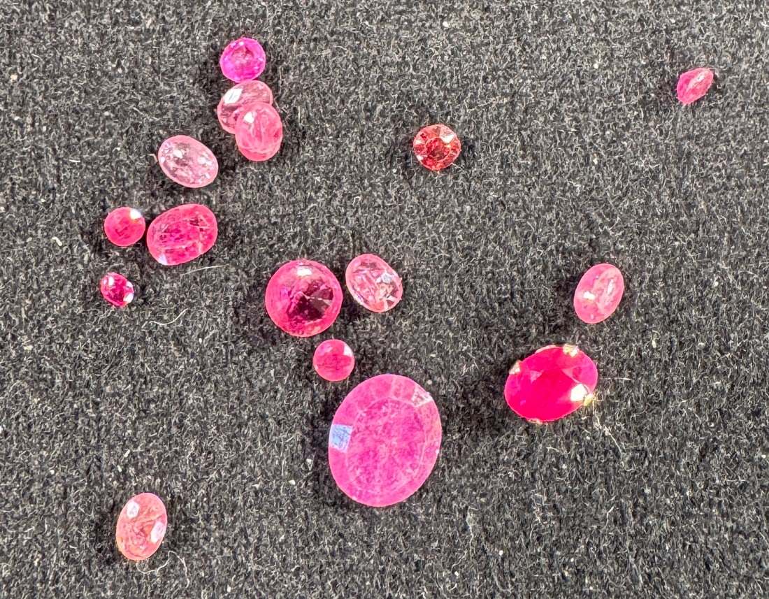 Lot of Faceted Pink Gemstones: A collection of faceted pink gemstones of varying sizes and shapes. Includes round, oval, and other cuts.