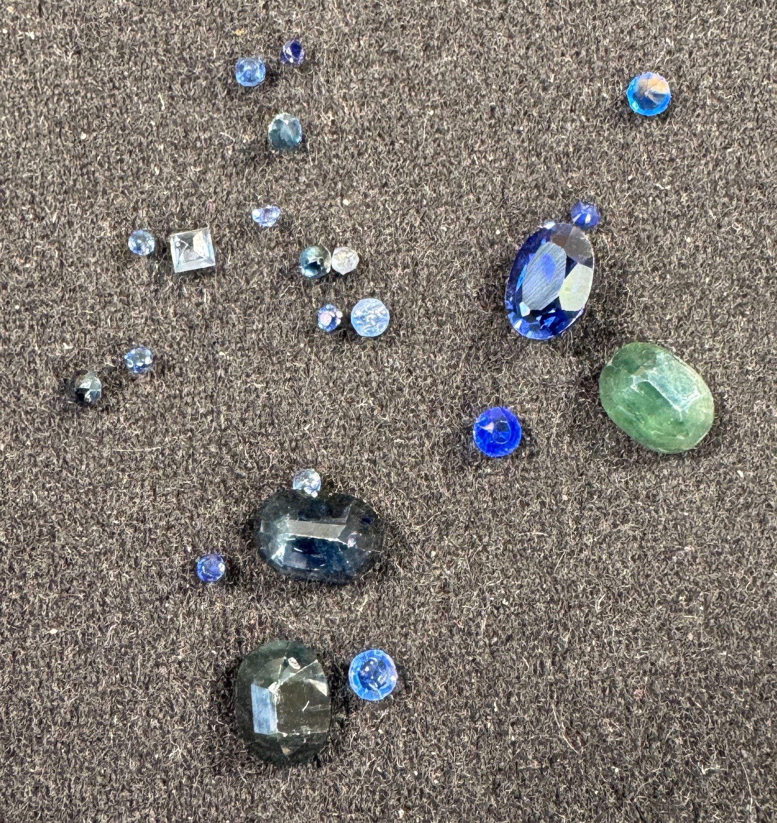 Loose Sapphire and Other Gemstone Assortment: A collection of loose gemstones, including sapphires and other stones. Total weight approximately 0.3 oz. Various cuts and sizes. See images for details.