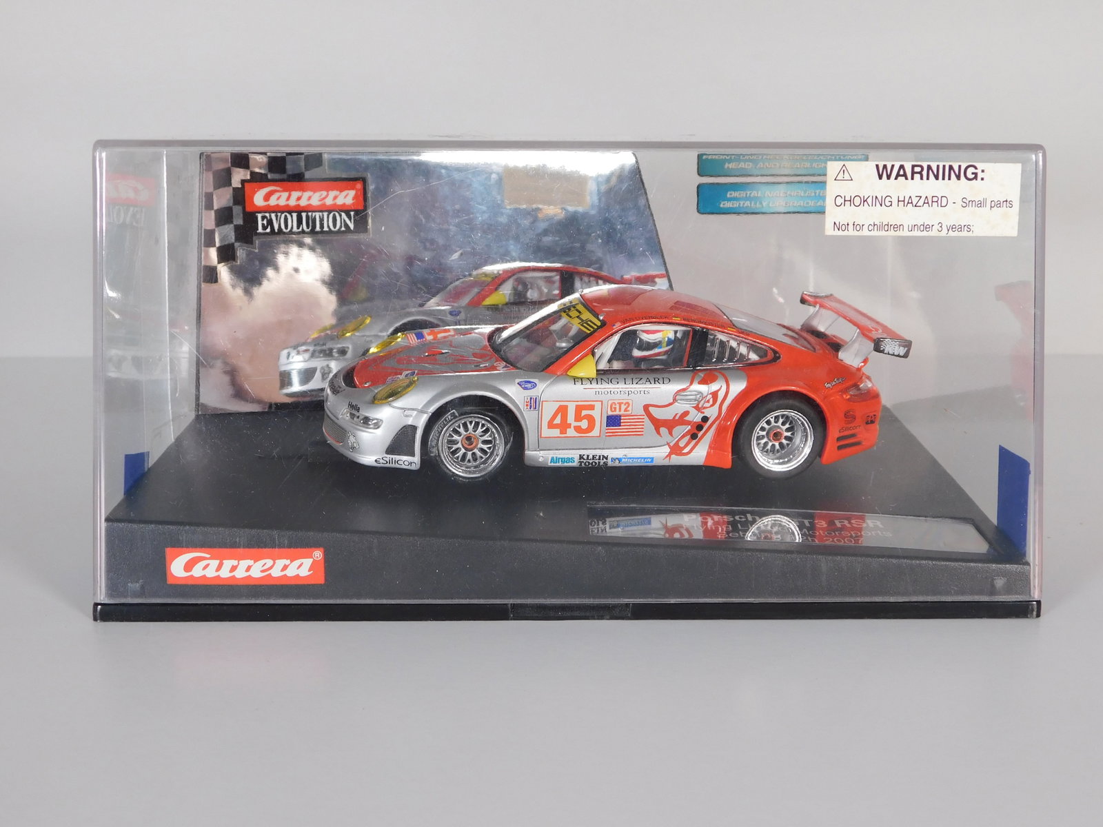 Carrera Evolution Porsche GT3 RSR Sebring 12h 2007 #45: Carrera Evolution Porsche GT3 RSR Flying Lizard Motorsports Sebring 12h 2007 #45 1/32 Slot Car. Reference #27210, with original case. Weight: 14.3 oz. Digitally upgradeable.