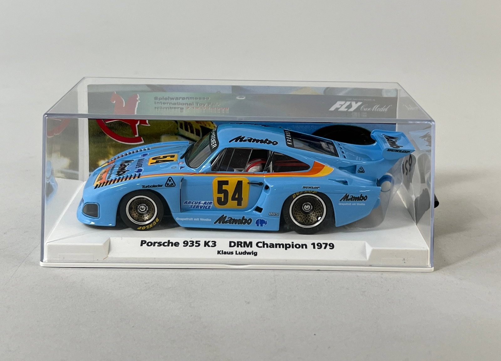 Fly Slot Car Porsche 935 K3 DRM Champion 1979 #54: Fly Slot Car - Porsche 935 K3 DRM Champion 1979 #54 Mambo 1/32 Slot Car. The model is presented in its original clear display case. Dimensions: 3.5" x 6.25" x 3.25". Weight: 6.3 oz.