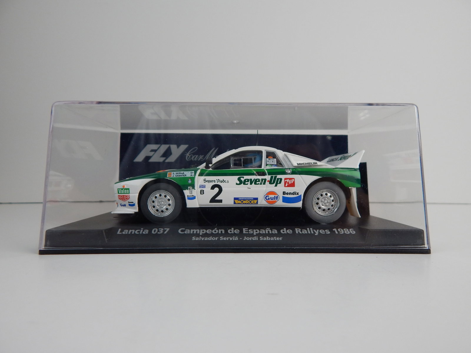 Fly Car Model Lancia 037 Campeon de Espana de Rallyes 1986 #2: Fly Car Model Lancia 037 Campeon de Espana de Rallyes 1986 Servia - Sabater #2 Seven Up 1/32 Slot Car. Reference #88148, with original case. Weight: 6.6 oz.