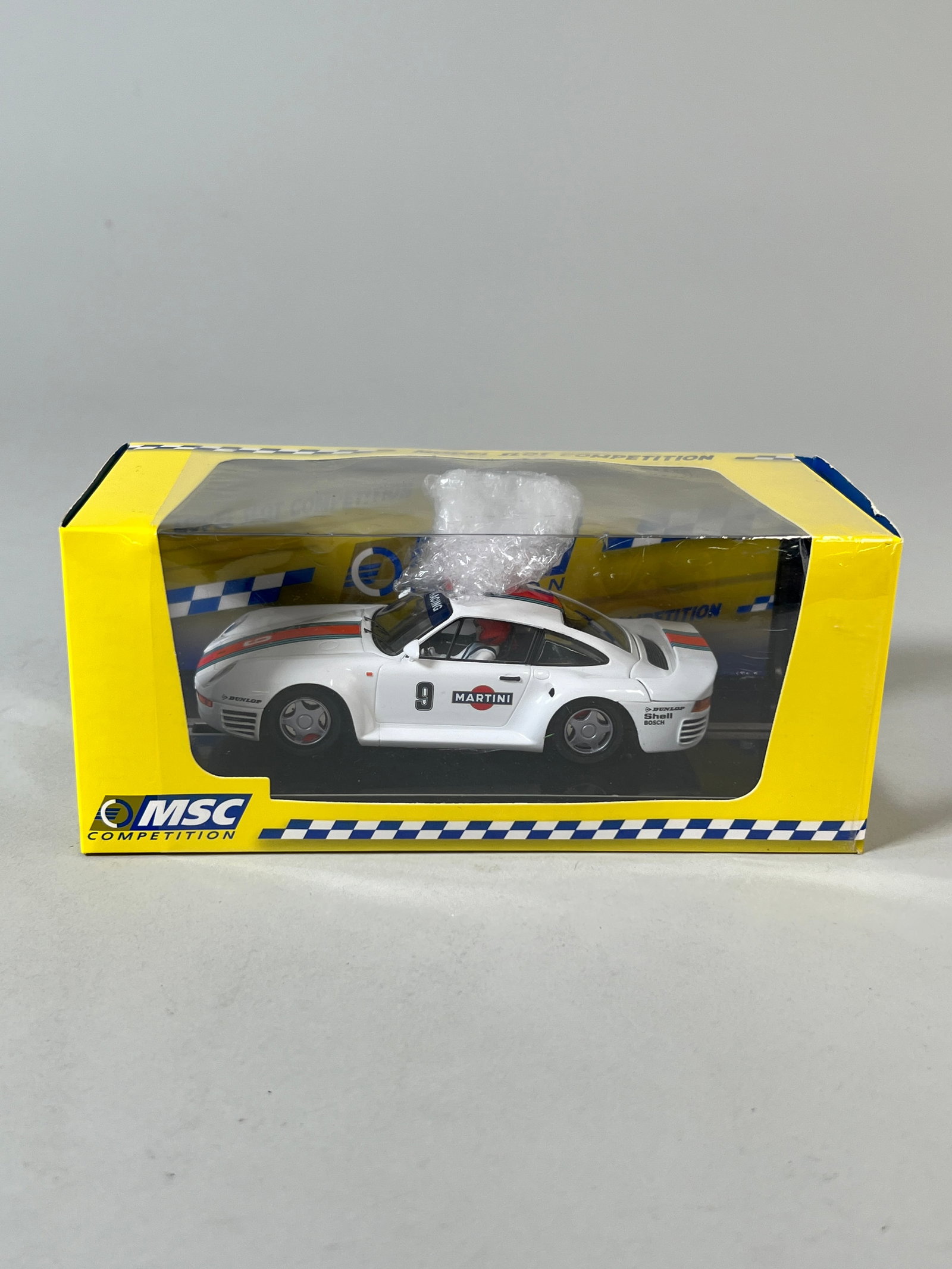 MSC Porsche 959 #9: MSC Porsche 959 Martini-Montecarlo chasis #9 1/32 Slot Car. It is presented in its original case. Dimensions: 4'' x 8'' x 3.75''. Weight: 7.6oz.