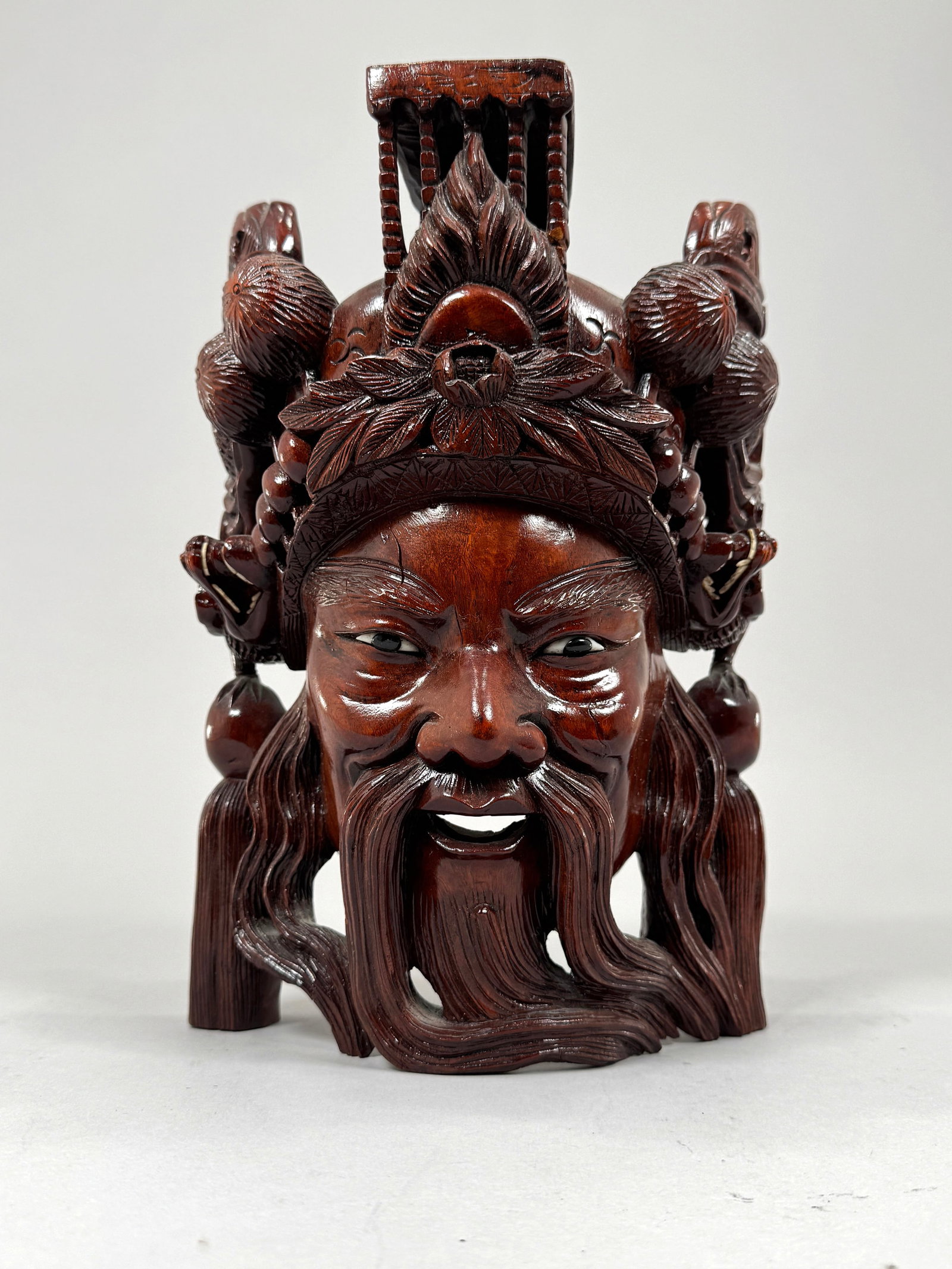 Chinese Rosewood Carved Mask: Chinese carved wooden mask, with inlaid details in eyes. Dimensions: 12 1/4" x 8 1/2" x 5 1/2" Weight: 5 lb 11 oz