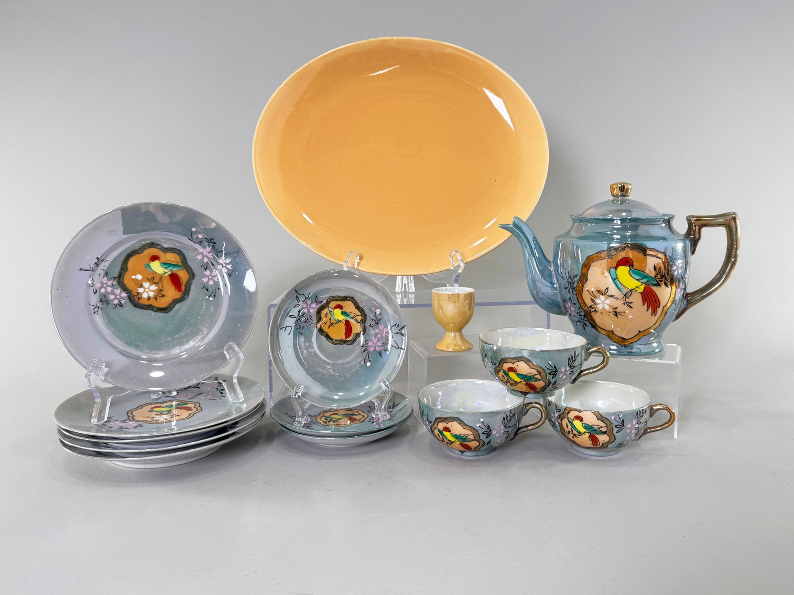 Japanese Lusterware Tea Group with Bird Motif: Vintage Japanese tea group featuring a bird and floral motif, paired with an orange platter by Cavitt-Shaw. Largest plate measures 13.5 inches. Total weight: 5lb 6oz. 