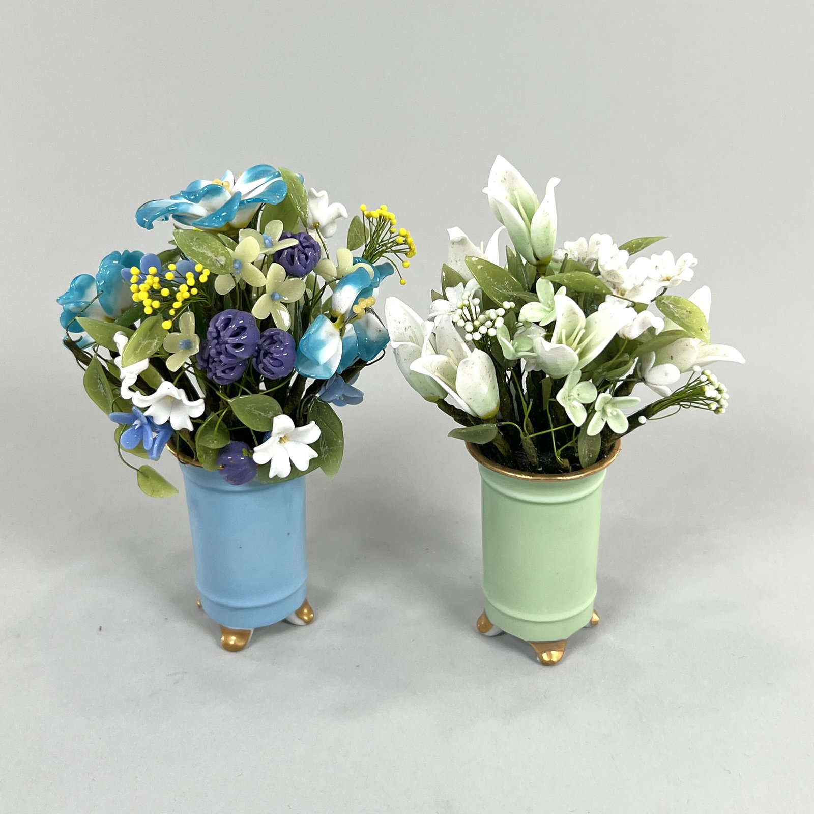 Two Miniature Glass and Porcelain Flower Arrangements: Two miniature glass floral arrangements in porcelain vases. One is marked Japan on underside. Weight: 14oz. Length: 6'' tall approx. 