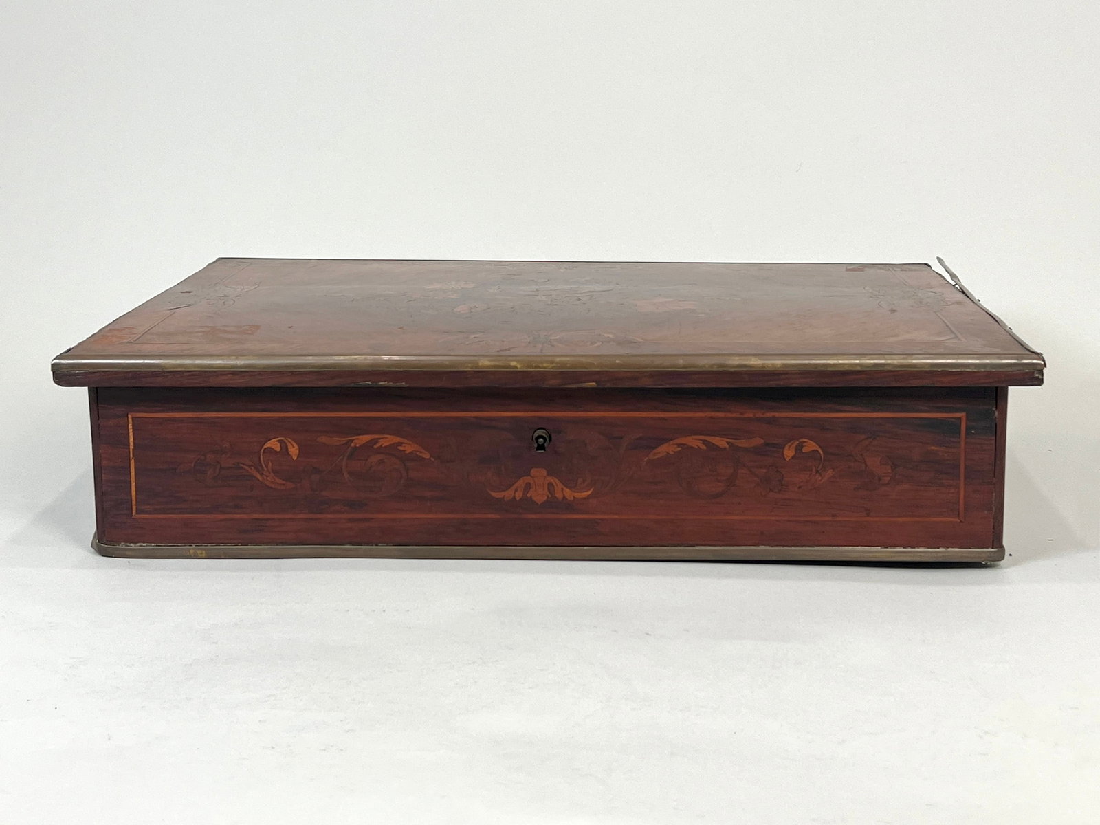 Marquetry Inlaid Box with Floral Motif: A wooden box featuring marquetry inlay on the lid. The box has a keyhole on the front. Weight: 11lb 9oz. Dimensions: 22" x 14.25".