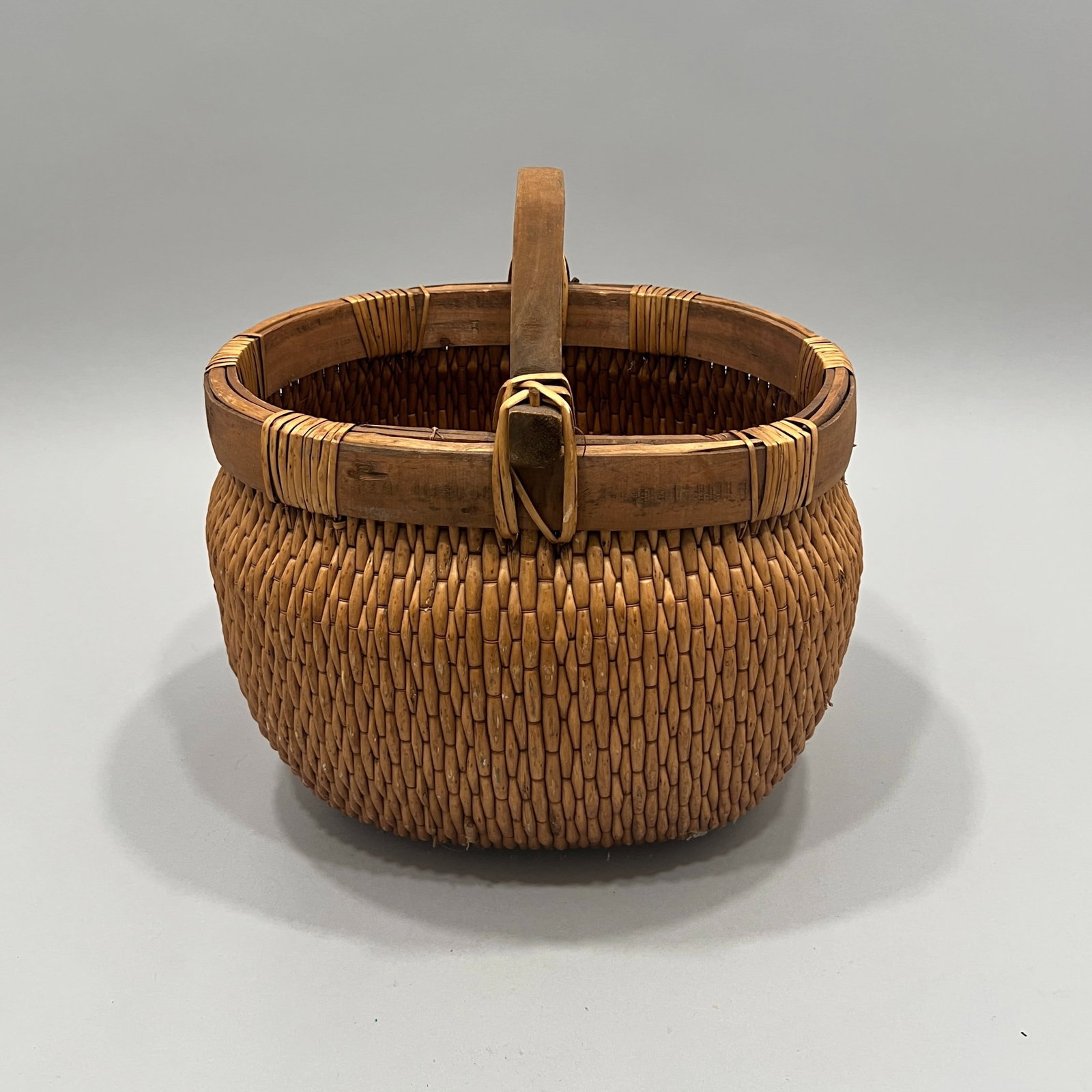Vintage Rattan Basket with Wooden Handle: A vintage rattan basket with a wooden handle and rim. Approximately 18 inches tall. Weighs 2lb 13oz