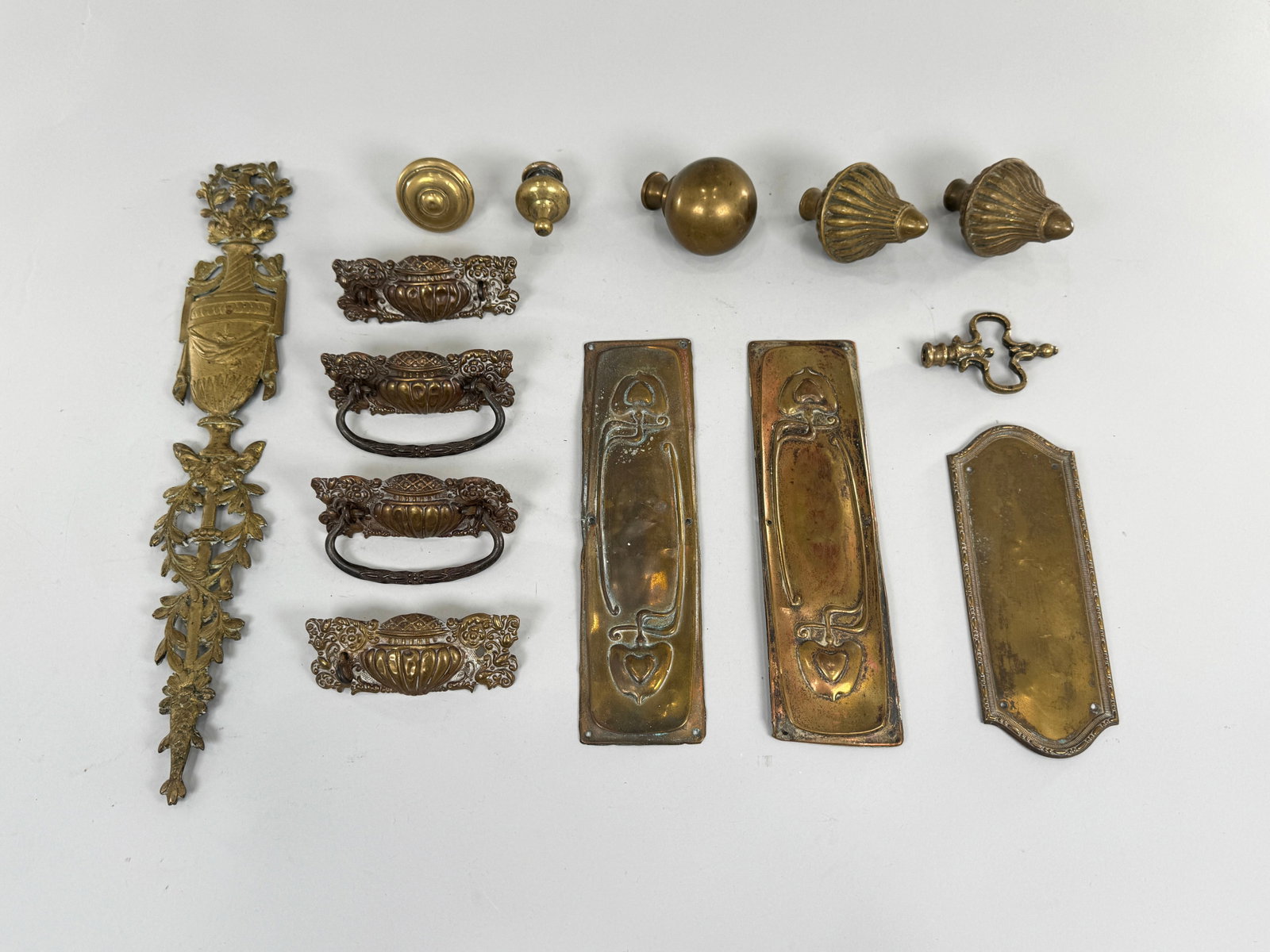 Antique Brass Hardware Assortment: Collection of antique brass hardware including pulls, knobs, and plates. Largest piece measures approximately 18 inches. Total Weight: 3lb 6oz. 
