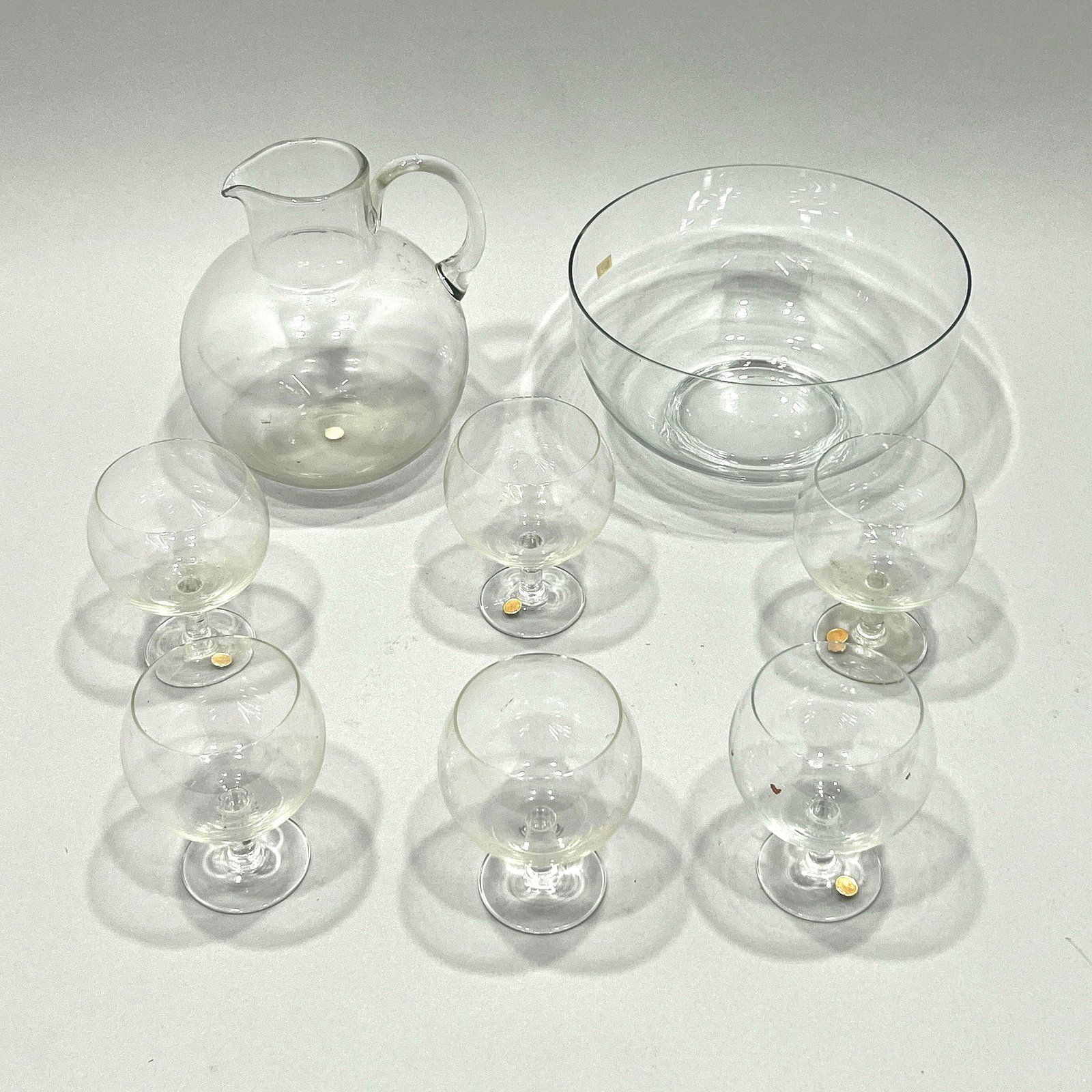 Glass Sangria Set and Bowl: A glass sangria set including a pitcher and six stemmed glasses marked "Made in Romania" and a glass serving bowl. The tallest item measures 9 inches and the total weight is 6lb 6oz.