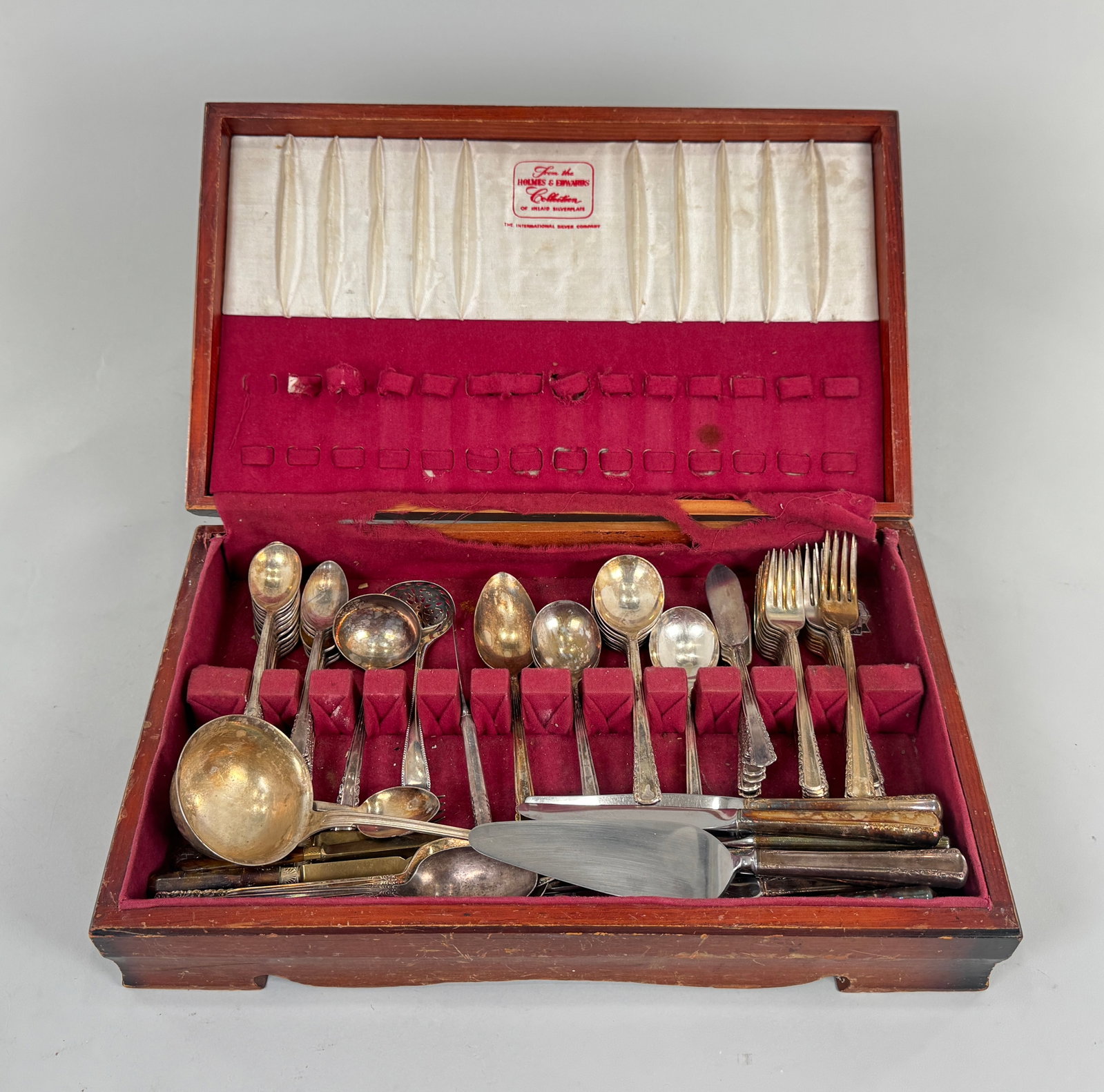 Silver Plated Flatware in Wooden Case: Silver plated flatware in a wooden case. Includes spoons, forks, knives, and serving utensils. The largest piece measures approximately 19 inches. Total weight is approximately 13 lb 5oz.