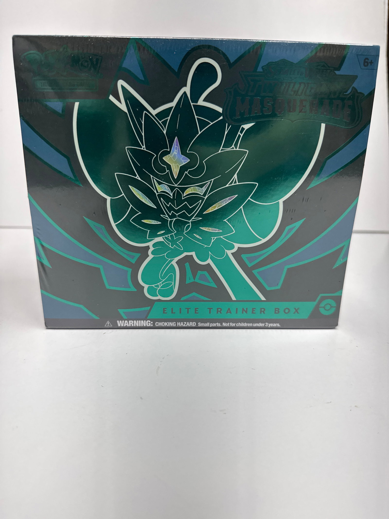 Pokemon TCG: Scarlet & Violet - Twilight Masquerade Elite Trainer Box: This is a sealed Pokemon TCG Elite Trainer Box from the Scarlet & Violet - Twilight Masquerade expansion. It features artwork of Ogerpon and includes booster packs, card sleeves, energy cards, damage 