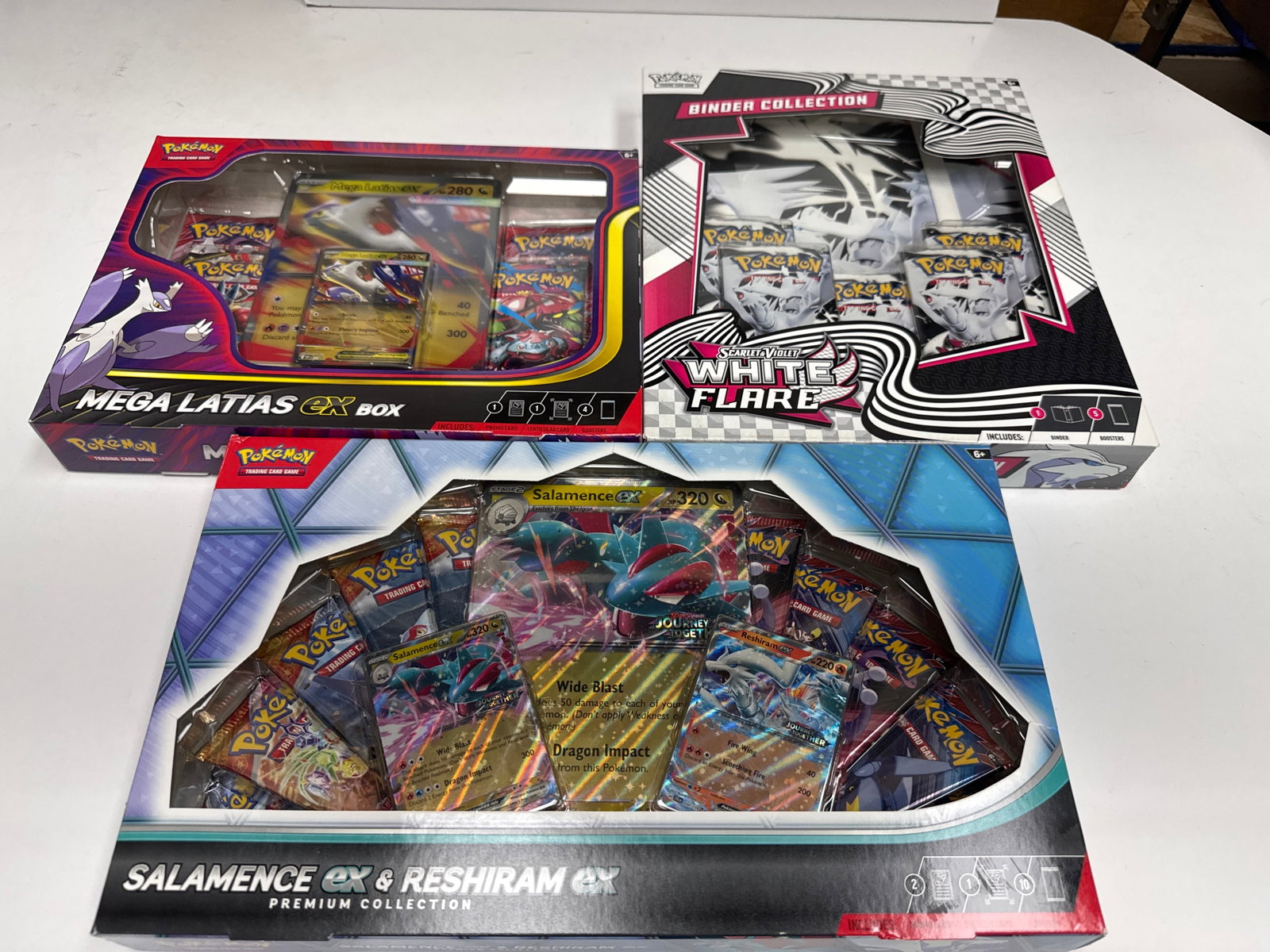 Pokemon TCG Mega Latias EX, Salamence EX & Reshiram EX Premium Collections, and Scarlet & Violet: This lot includes three Pokemon Trading Card Game premium collections: Mega Latias EX, Salamence EX & Reshiram EX, and a Scarlet & Violet: Scarlet & Violet - 151 Binder Collection. Each collection con
