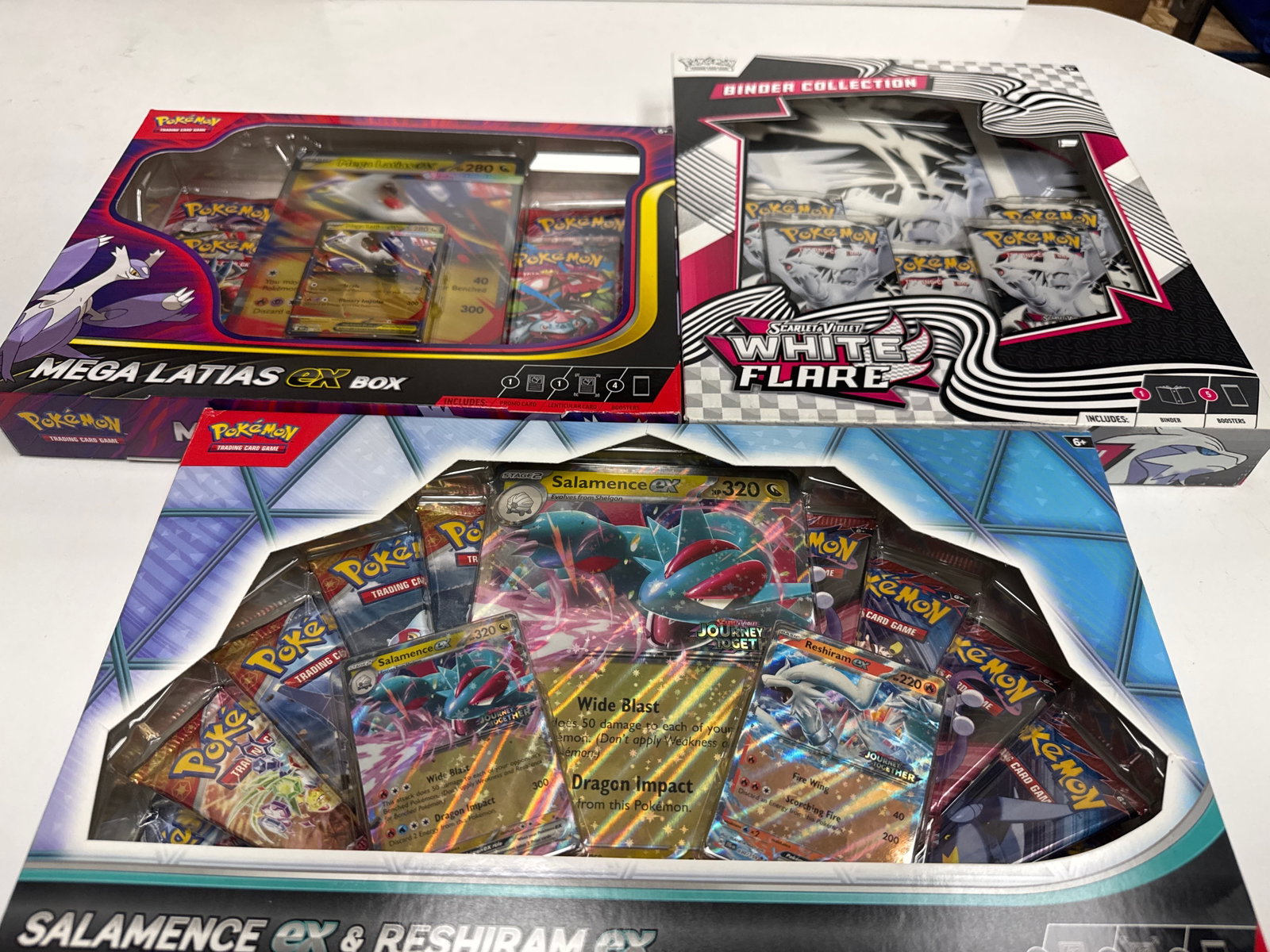 Pokemon TCG Mega Latias EX Box, Binder Collection, and Salamence EX & Reshiram EX Premium Collection: This lot includes three Pokemon Trading Card Game (TCG) collections: the Mega Latias EX Box, the Scarlet & Violet: 151 White & Flare Binder Collection, and the Salamence EX & Reshiram EX Premium Colle