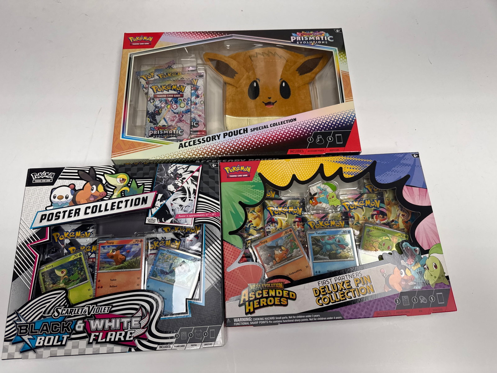 Pokemon TCG: Prismatic Evolutions Special Collection, Scarlet & Violet Black & White Flare, and: This lot includes three Pokemon Trading Card Game collections: the Prismatic Evolutions Special Collection with an Eevee accessory pouch and booster packs, the Scarlet & Violet Black & White F