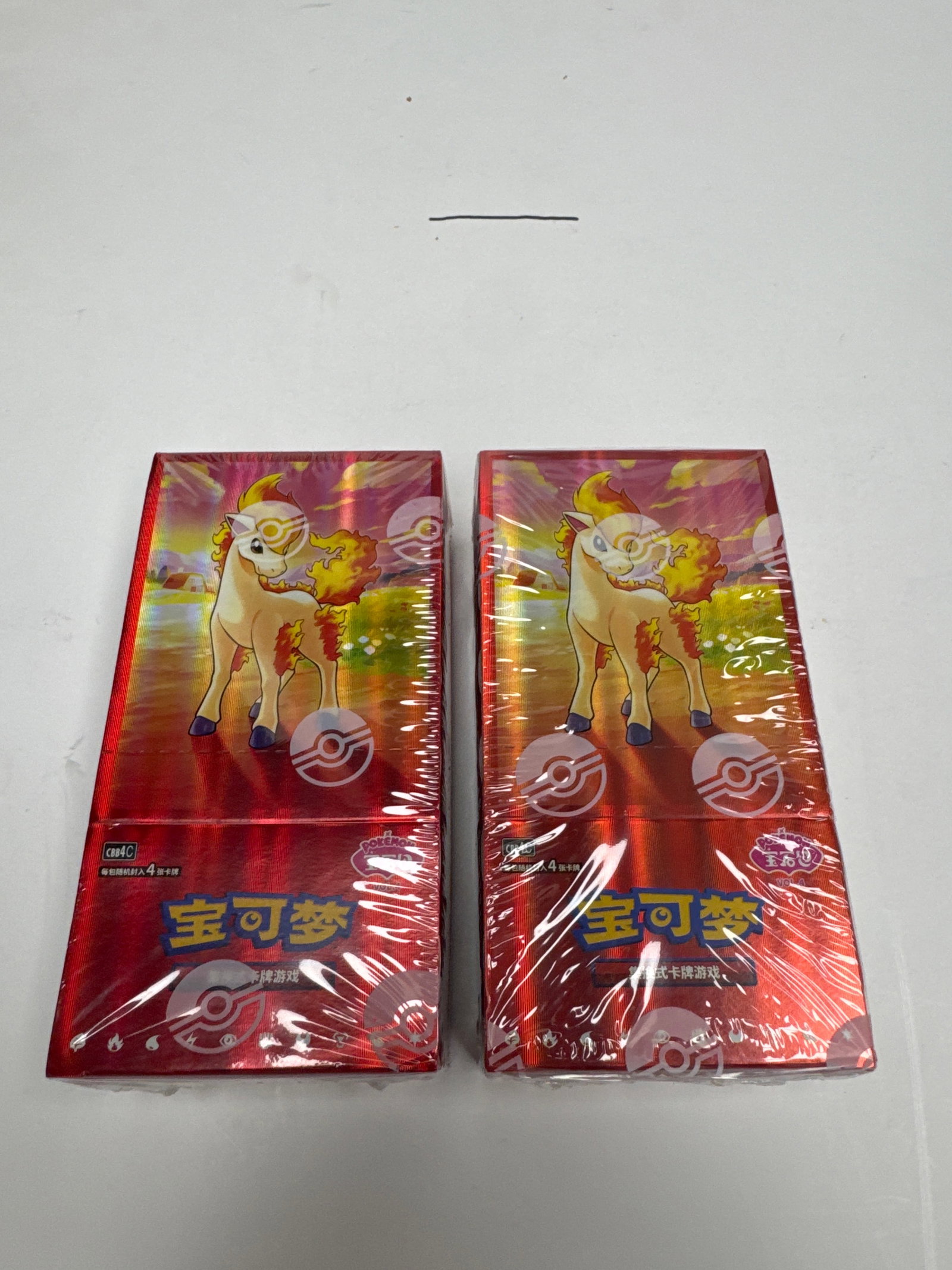 Two Sealed Pokemon Card Booster Boxes: This lot contains two sealed booster boxes of Pokemon trading cards. The boxes are red with images of Pokemon characters and the Pokemon logo. They appear to be in excellent condition, with no visible