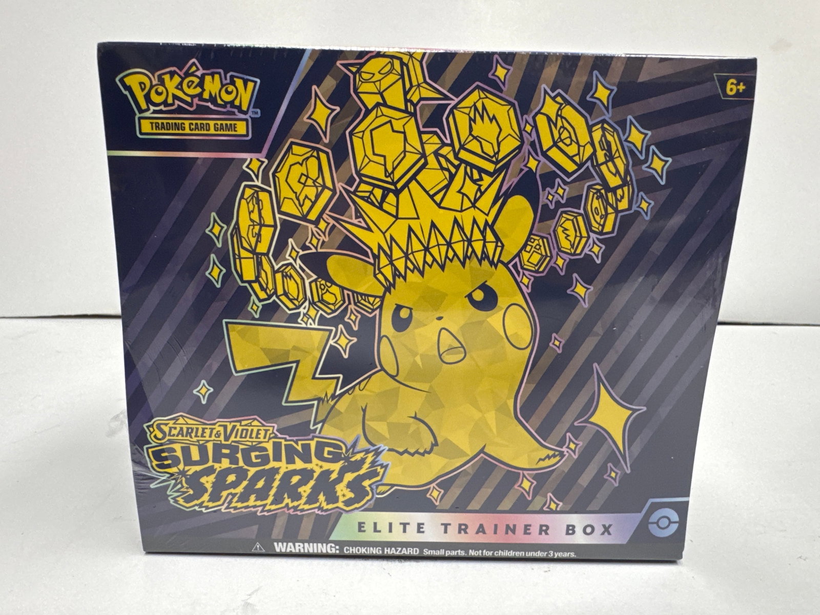 Pokemon Scarlet & Violet: Surging Sparks Elite Trainer Box: Sealed Pokemon Scarlet & Violet: Surging Sparks Elite Trainer Box. Features Pikachu on the cover and includes 9 booster packs, 1 foil promo card, 65 card sleeves, 45 TCG energy cards, a player's guide