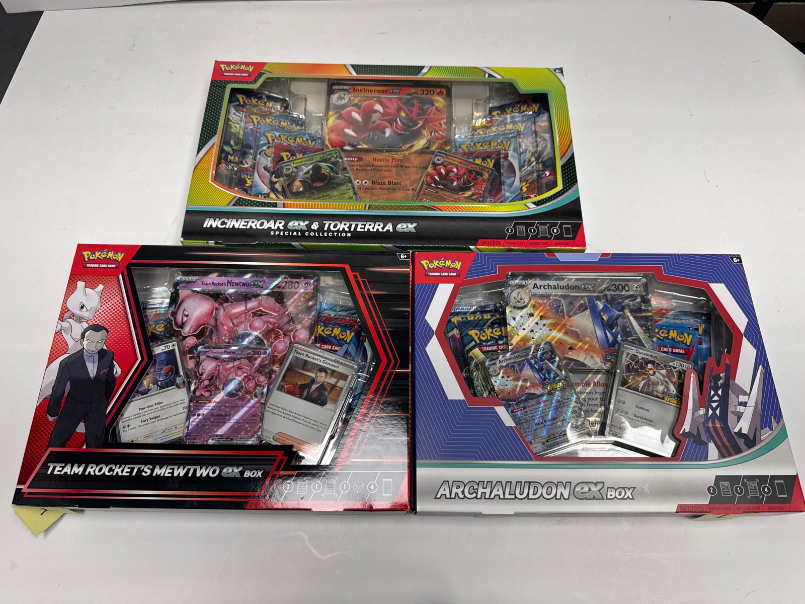 Pokemon TCG Special Collection Boxes: Incineroar EX & Torterra EX, Team Rocket's Mewtwo EX, and: This lot features three Pokemon Trading Card Game Special Collection Boxes: Incineroar EX & Torterra EX, Team Rocket's Mewtwo EX, and Arcaludon EX. Each box contains booster packs, foil cards, and oth
