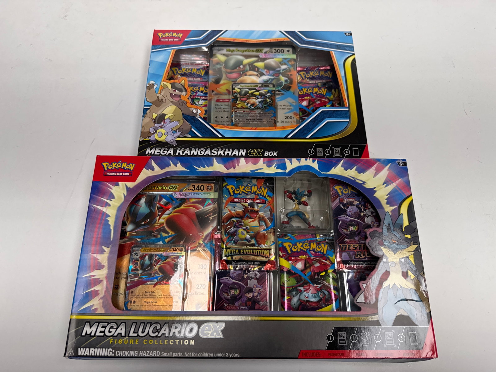 Pokemon TCG Mega Kangaskhan EX Box and Mega Lucario EX Figure Collection: This lot includes two Pokemon Trading Card Game collector's boxes: the Mega Kangaskhan EX Box and the Mega Lucario EX Figure Collection. Both boxes contain booster packs and promotional cards, offerin