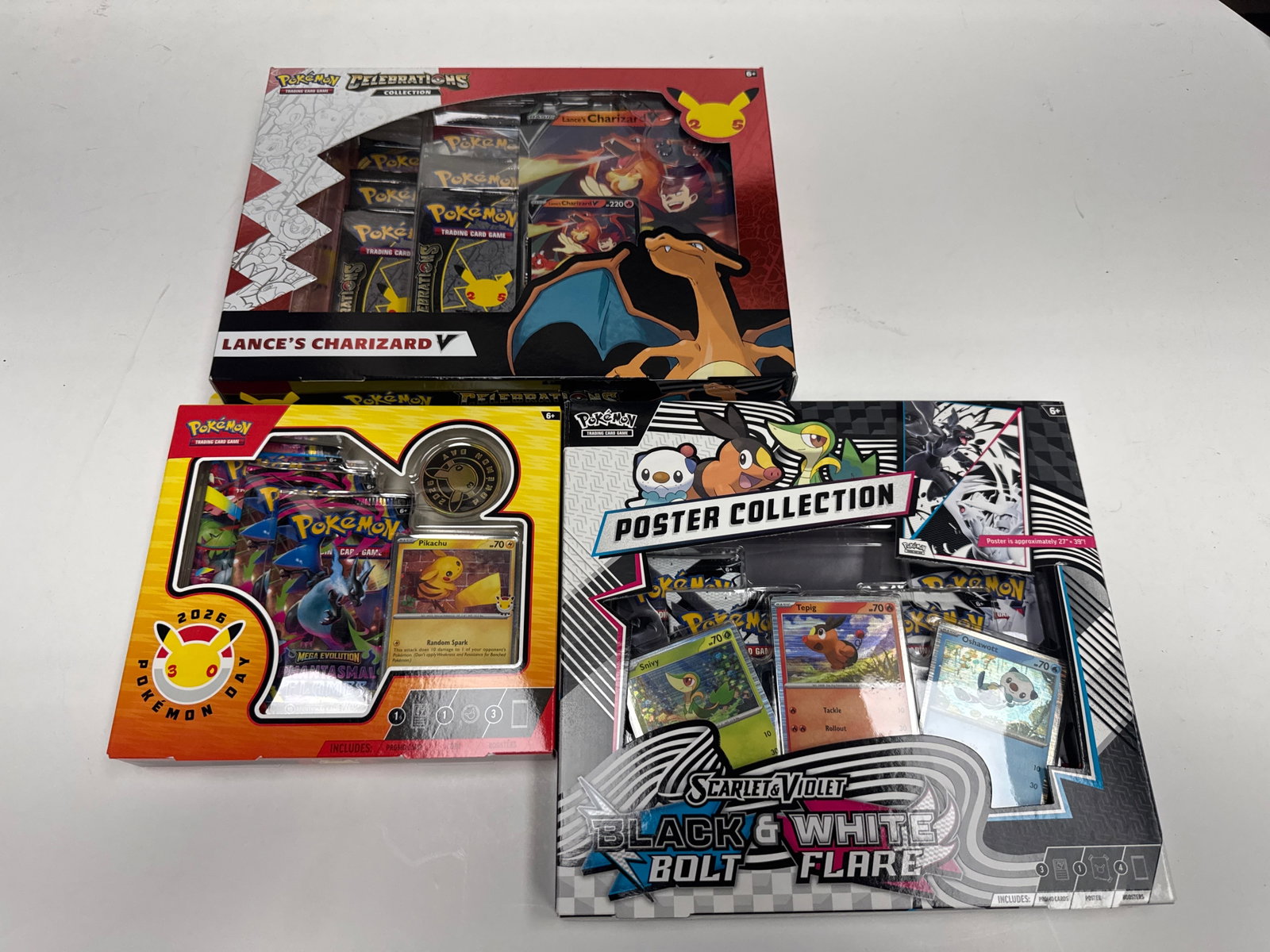 Pokemon TCG: Lance's Charizard V, 2026 Pokemon Day, and Scarlet & Violet Black & White Bolt Flare: This lot includes three Pokemon Trading Card Game collections: Lance's Charizard V Celebrations Collection, the 2026 Pokemon Day 2026 Collection, and the Scarlet & Violet Black & White Bolt Flare Post