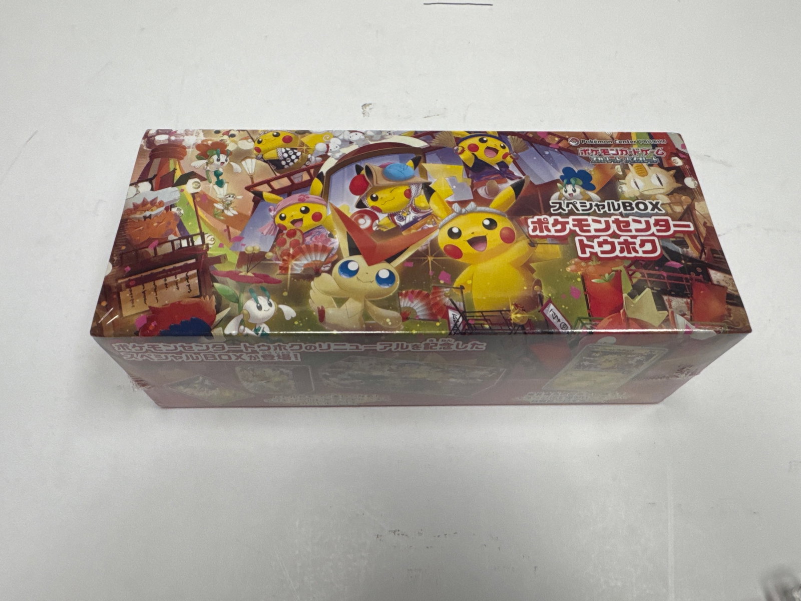 Pokemon Center Tohoku Renewal Special Box: This is a special edition Pokemon Center Tohoku Renewal Special Box. It includes a special promo card, deck shields, deck cases, and a long card box. The box features vibrant artwork with various Poke