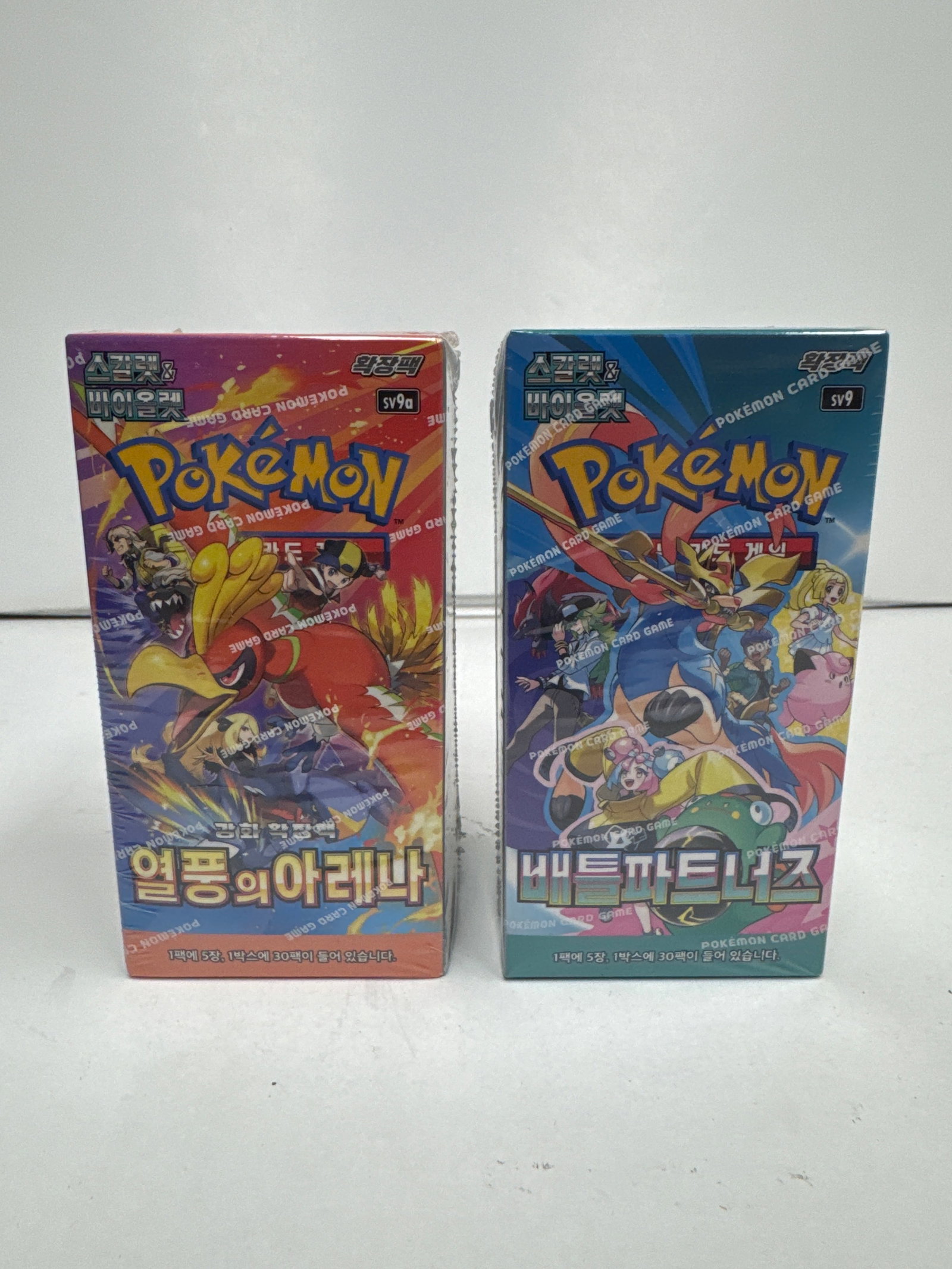 Two Sealed Pokemon Card Game Booster Boxes: "Snowy Mountains" and "Battle Partners": This lot features two sealed Pokemon Card Game booster boxes. The first box, titled "Snowy Mountains" (Korean: "ì–¼ì?Œì?˜ ì•„ë ˆë‚˜"), is sealed in its original plastic wra