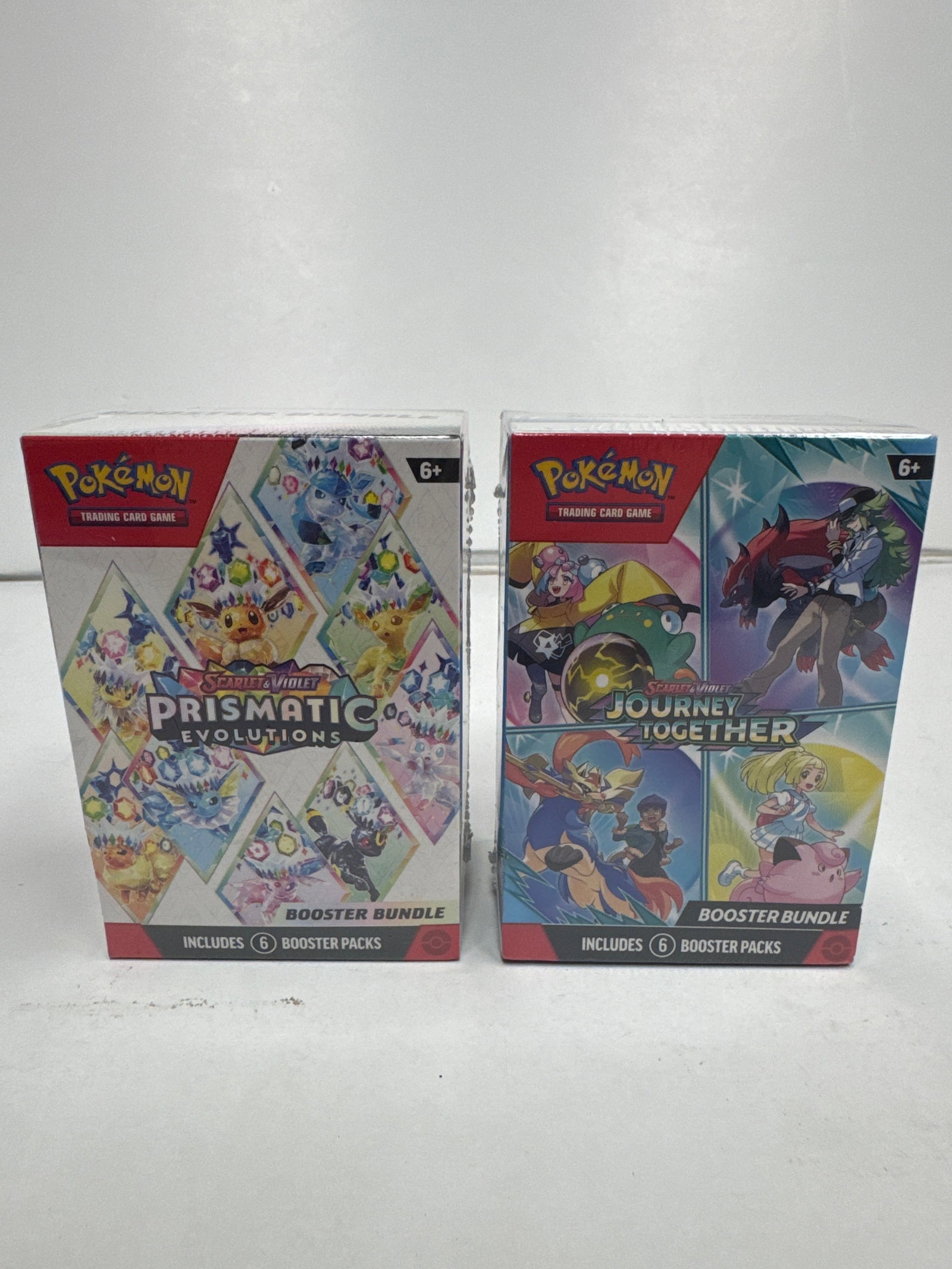 Pokemon TCG: Scarlet & Violet - Prismatic Evolutions & Journey Together Booster Bundles: Two sealed Pokemon Trading Card Game Booster Bundles: 'Scarlet & Violet - Prismatic Evolutions' and 'Scarlet & Violet - Journey Together'. Each bundle contains 6 booster packs, offering a chance to ex