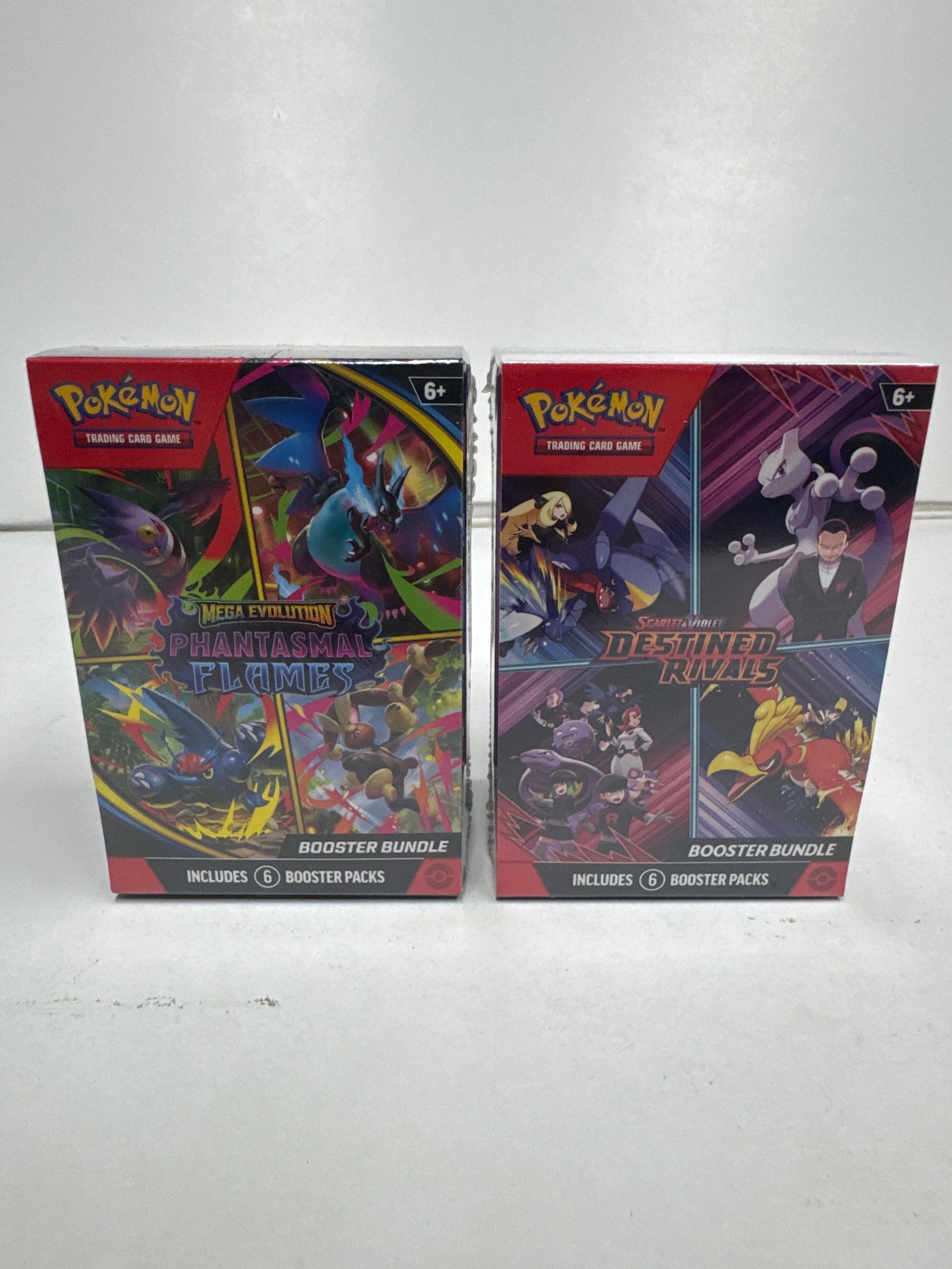 Pokemon TCG Booster Bundles: Mega Evolution Phantasmals Flames & Scarlet & Violet Destined Rivals: Two Pokemon Trading Card Game Booster Bundles. One features Mega Evolution Phantasmals Flames, containing 6 booster packs. The other features Scarlet & Violet Destined Rivals, also containing 6 booste