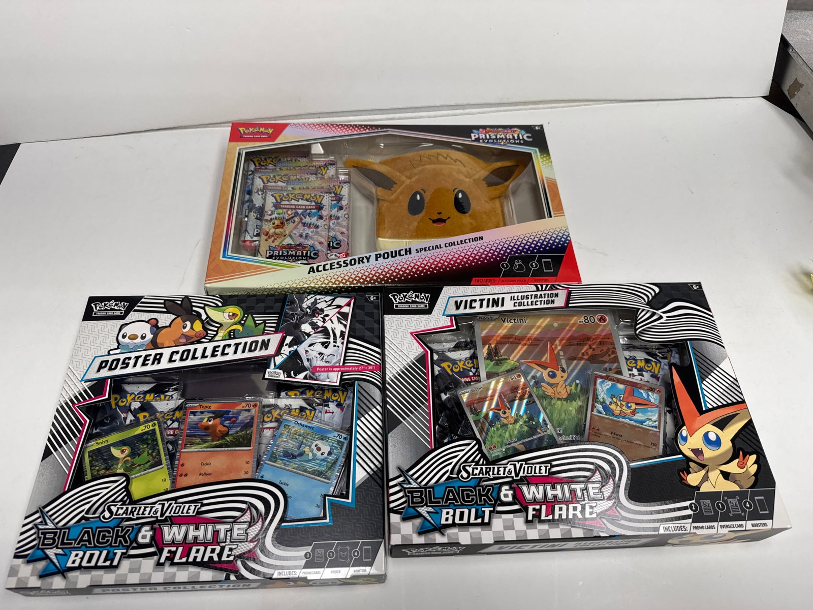 Pokemon Scarlet & Violet Black & White Flare Booster Packs and Collections: This lot includes three Pokemon TCG collections: the Scarlet & Violet-Prismatic Evolutions Accessory Pouch Special Collection featuring Eevee, the Scarlet & Violet Black & White Flare Poster Collectio