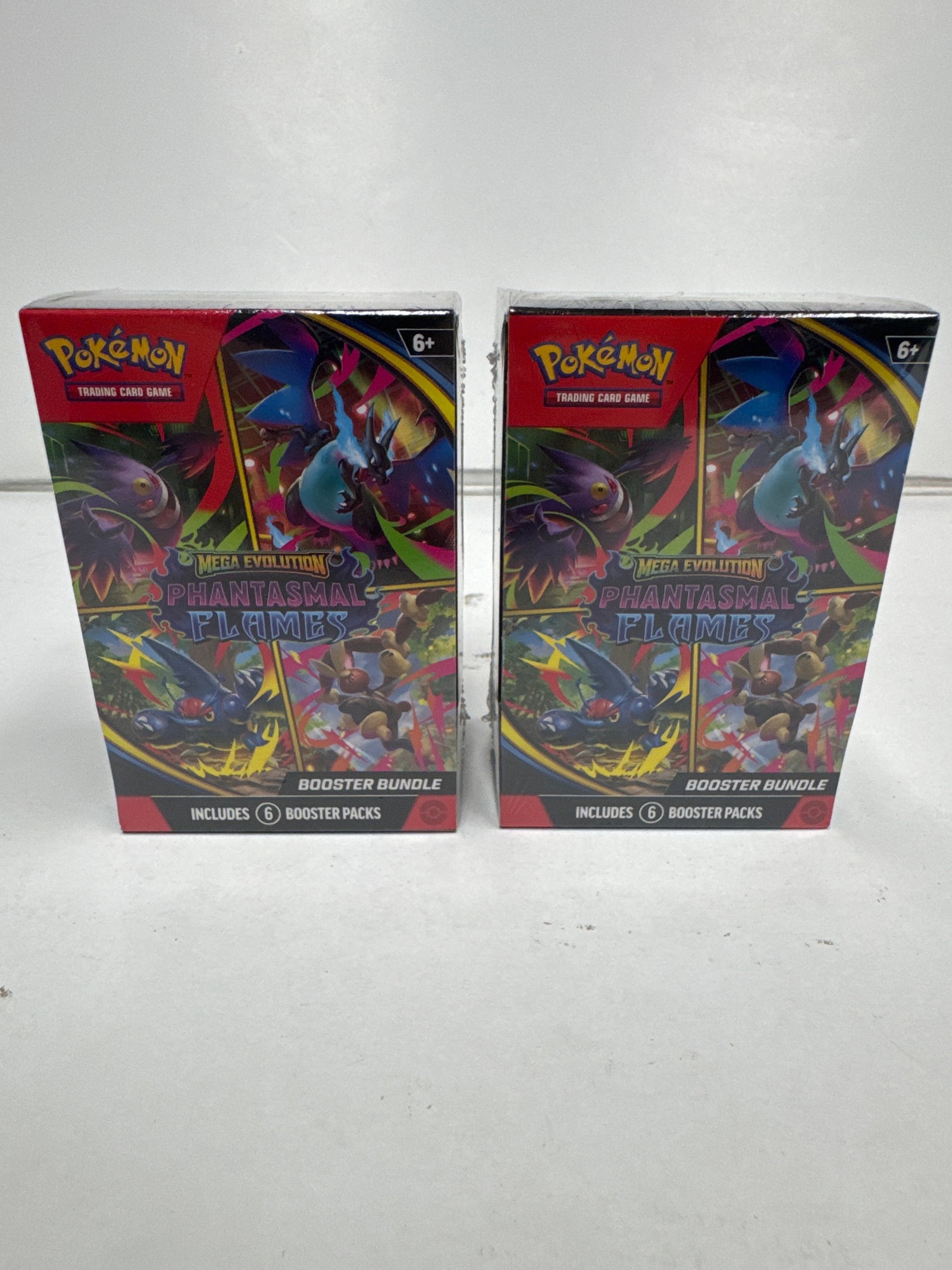 Pokemon TCG: Mega Evolution Phantasmals Flames Booster Bundle (2 Boxes): This lot includes two (2) Pokemon TCG: Mega Evolution Phantasmals Flames Booster Bundles. Each bundle contains six (6) booster packs, totaling twelve (12) booster packs. The Phantasmals Flames expansi