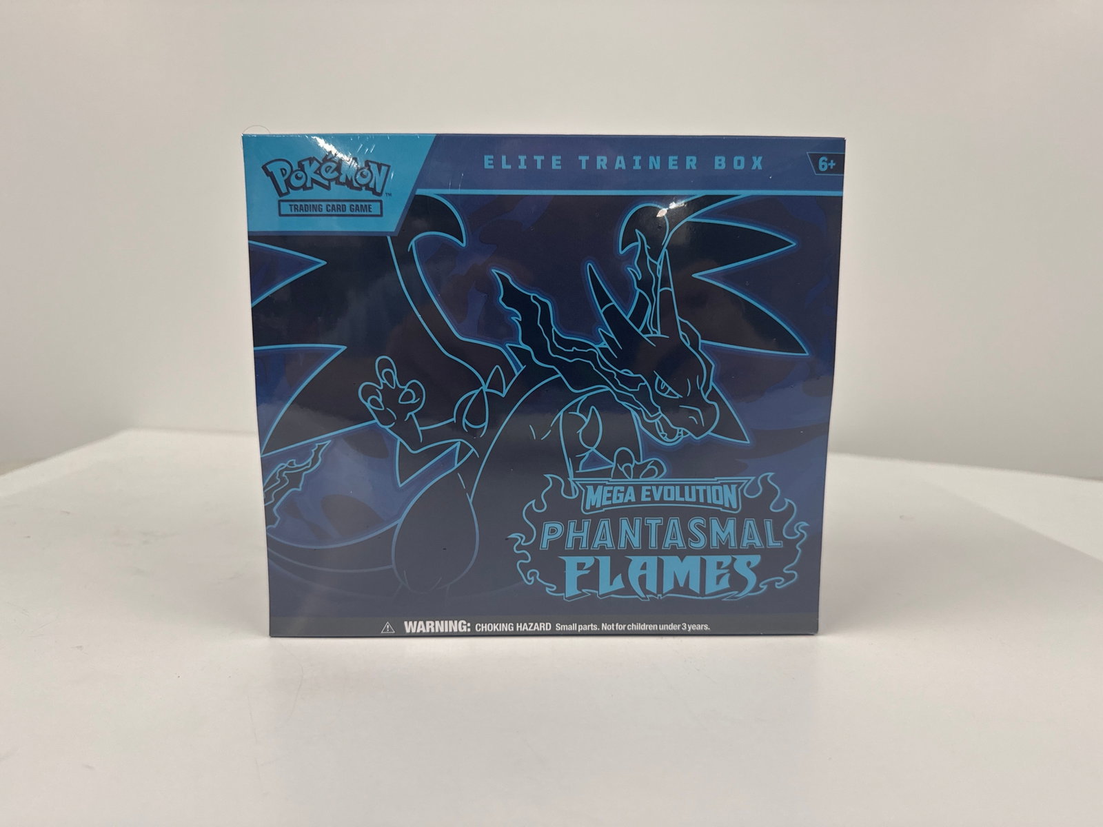 Pokemon Mega Evolution Phantasmal Flames Elite Trainer Box: Sealed Pokemon Elite Trainer Box from the Mega Evolution Phantasmal Flames expansion. This box contains 10 full-art promo cards featuring Charizard, 10 Pokemon TCG booster packs, card sleeves, dice,