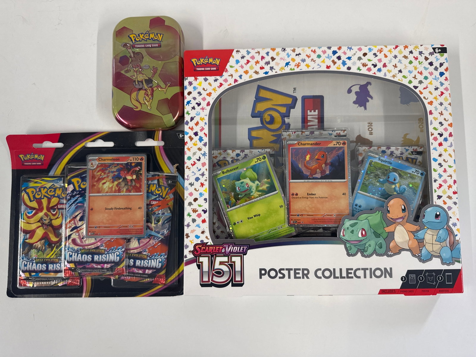 Pokemon TCG Scarlet & Violet 151 Poster Collection Box with Chaos Rising Booster Packs: This lot includes a Pokemon TCG Scarlet & Violet 151 Poster Collection Box featuring Bulbasaur, Charmander, and Squirtle, along with a metal tin and three Pokemon TCG Chaos Rising booster packs. The p