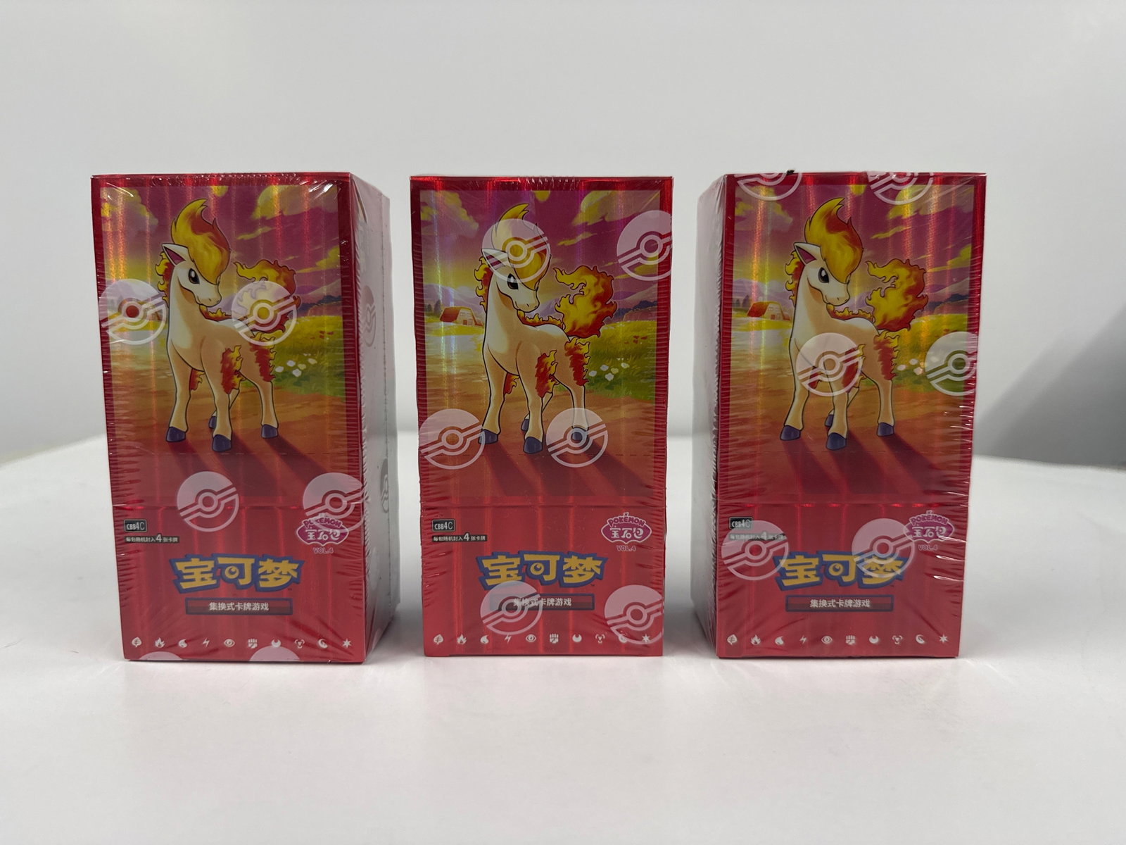 Three Sealed Pokemon Card Game Booster Boxes: This lot features three sealed booster boxes for the Pokemon Card Game. Each box is sealed in its original plastic wrap and displays vibrant artwork featuring Pokemon characters. The boxes appear to b