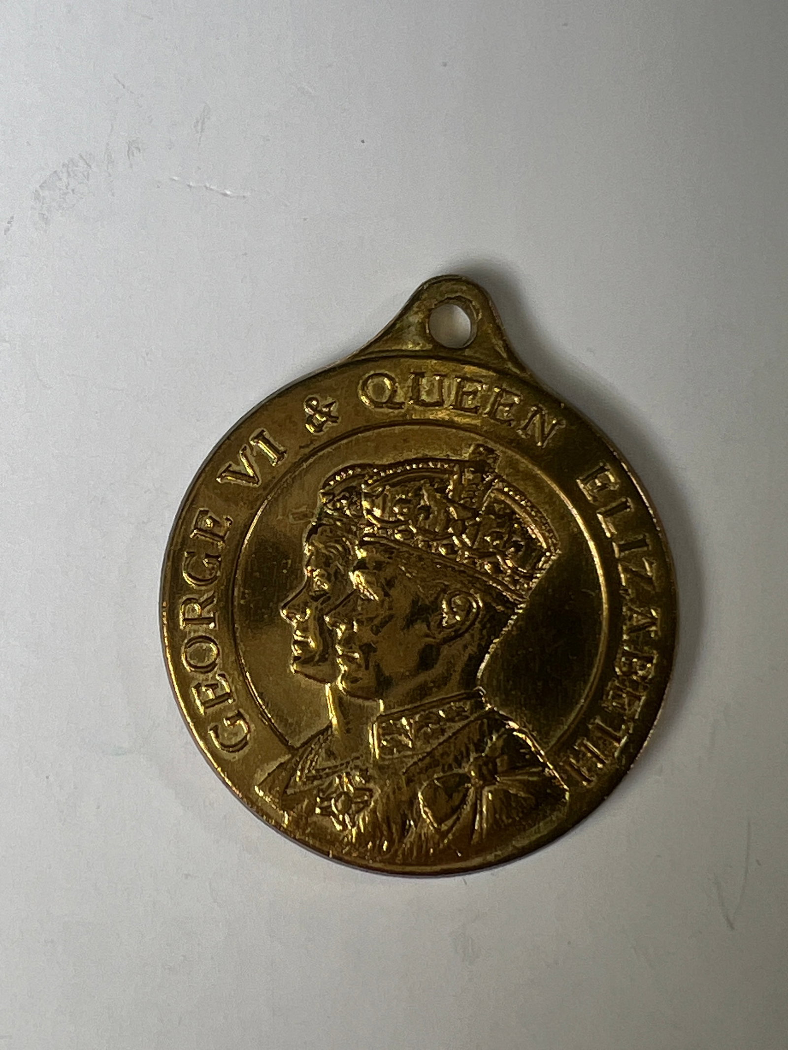 1937 George VI and Queen Elizabeth Coronation Medal: 1937 George VI Coronation Medal. Features a portrait of King George VI and Queen Elizabeth. The reverse depicts a crowned figure. Includes a loop for suspension.