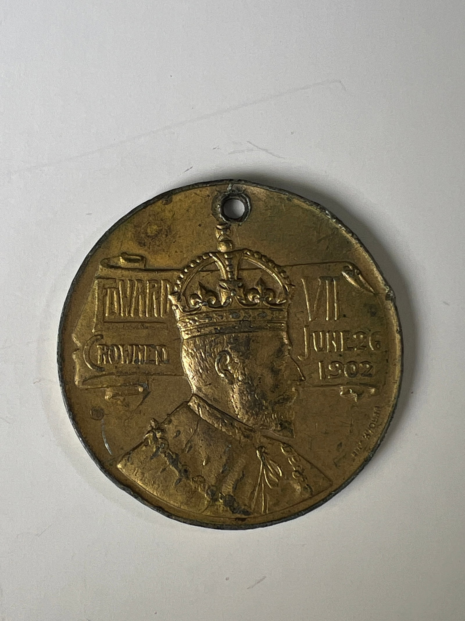1902 King Edward VII Coronation Medal: Commemorative medal for the coronation of King Edward VII, dated 1902. Features a portrait of the King on one side and a symbolic figure on the other. Pierced with a hole.