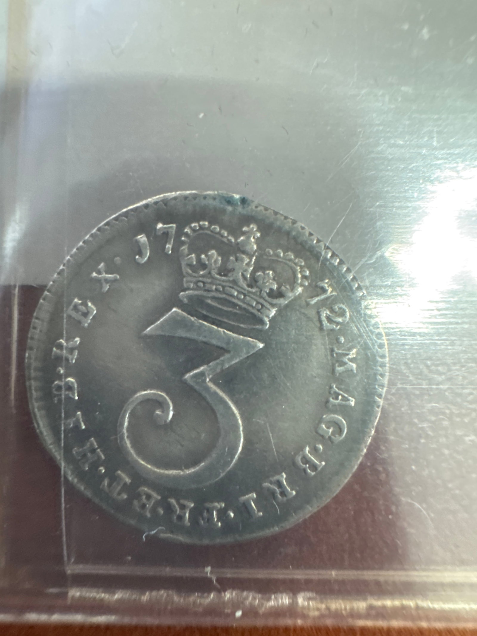 United Kingdom 3 Pence: A silver shilling coin featuring King George III on the obverse and the numeral '3' with a crown on the reverse. 
