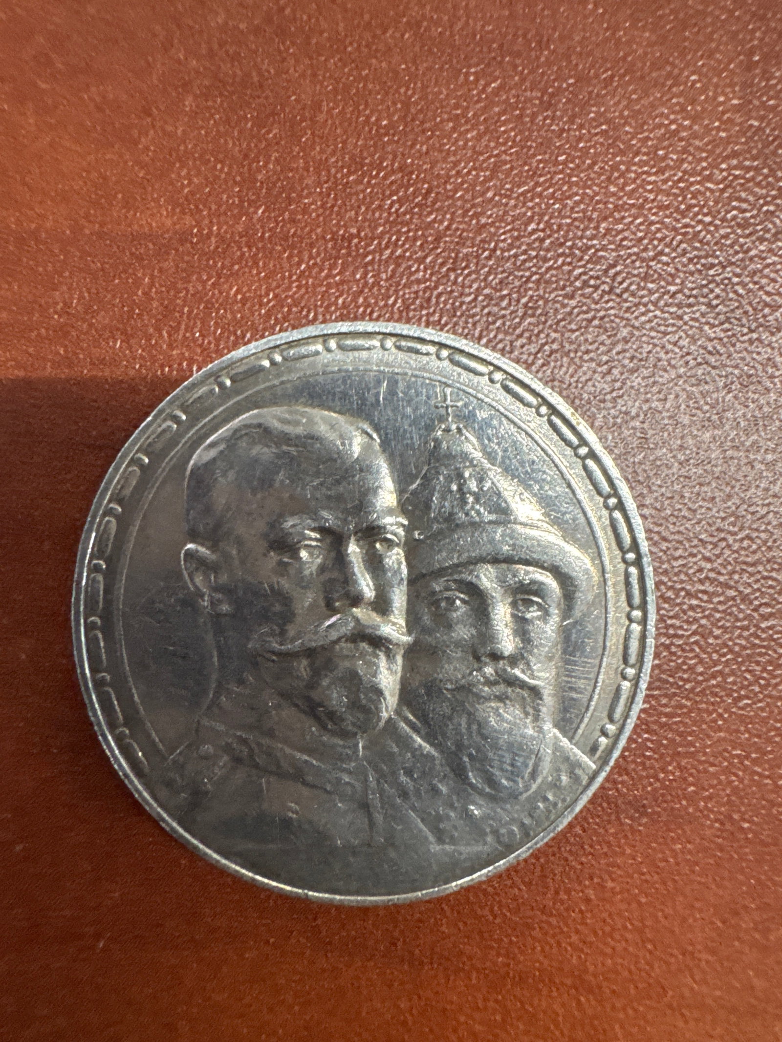 1913 Russian Ruble Coin: A silver Russian Ruble coin dated 1913, 300th anniversary of Romanov Dynasty. The reverse displays the Imperial Russian coat of arms, a double-headed eagle, and the inscription '1613 - 1913'.