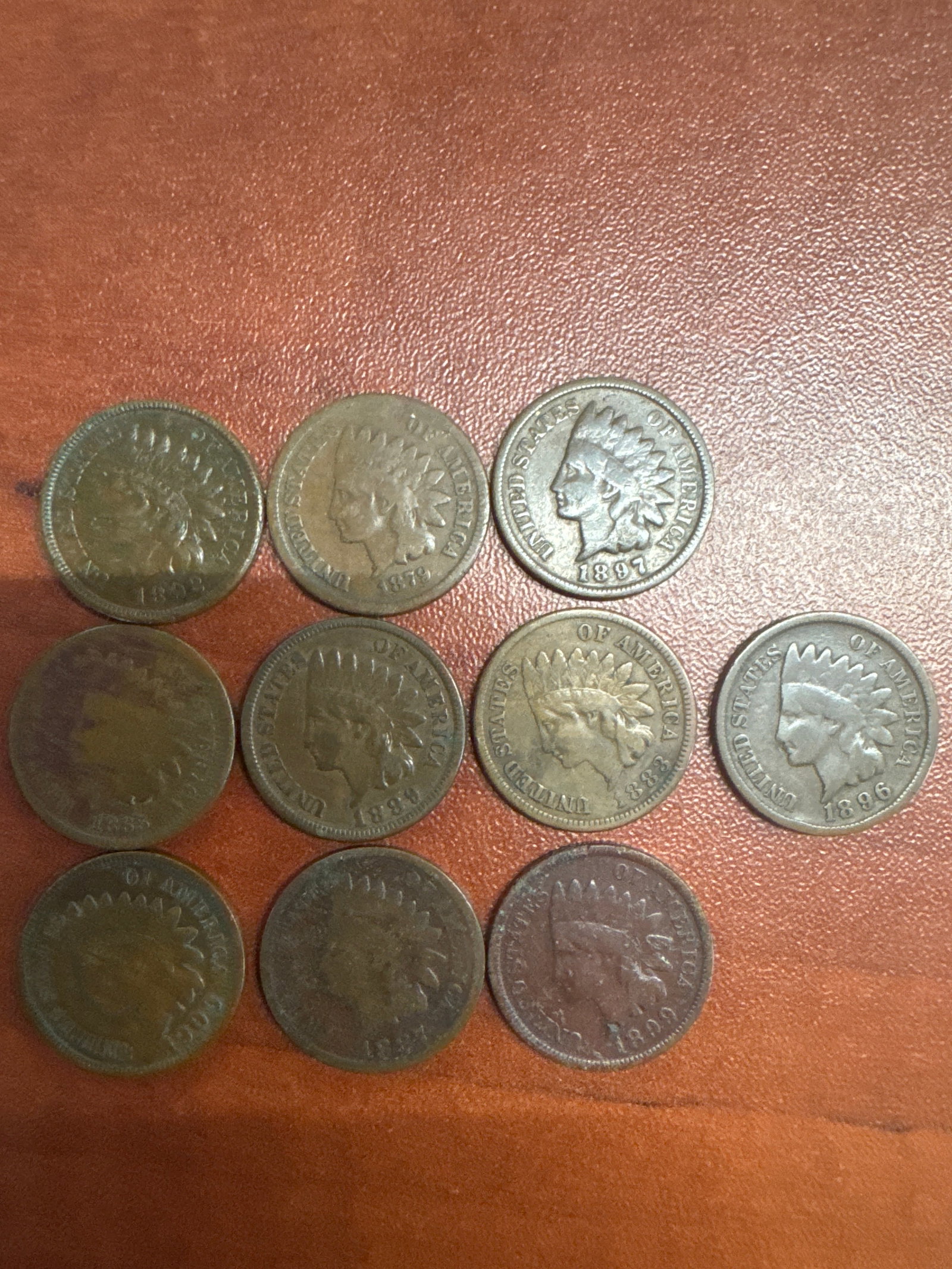 Collection of Indian Head Pennies: A collection of ten Indian Head pennies, featuring various dates including 1897, 1896, 1899, and others. The coins show signs of wear consistent with their age.