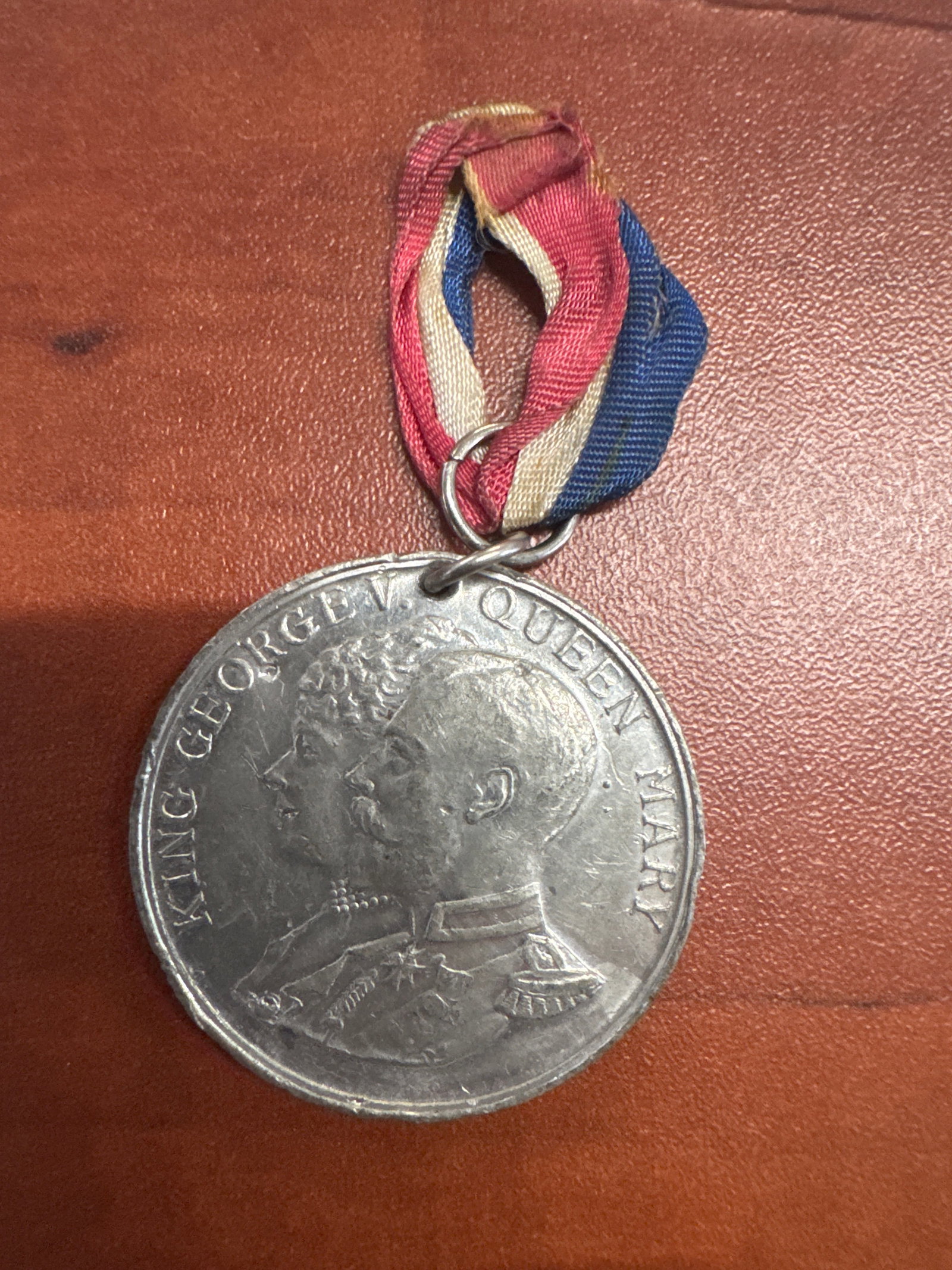 King George V and Queen Mary Silver Jubilee Medal, 1935: A commemorative medal celebrating the Silver Jubilee of King George V and Queen Mary, dated May 6th, 1935. The medal features portraits of the King and Queen on one side and the inscription 'To Co