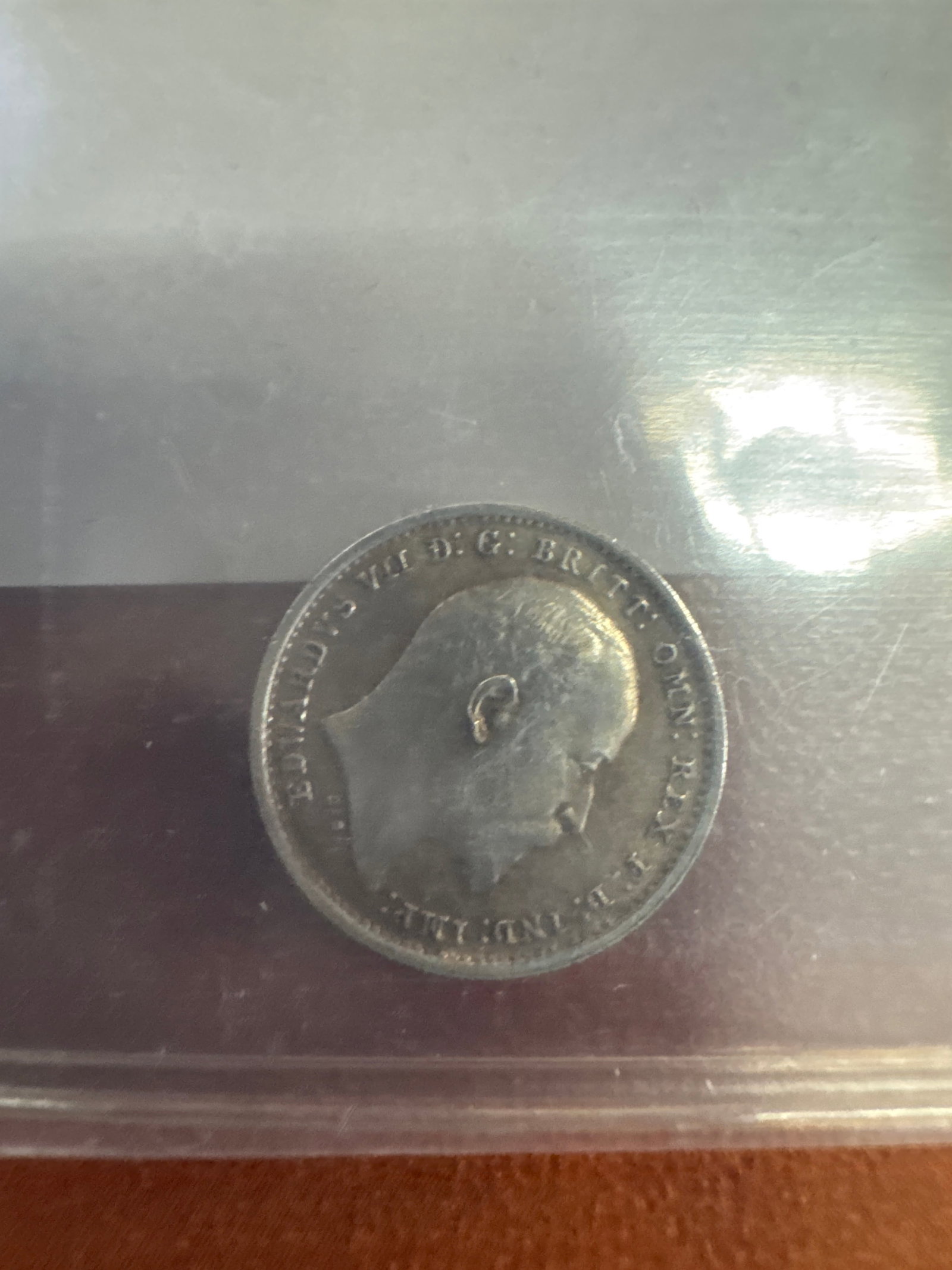 1902 British Two Pence Coin: A silver-colored coin featuring a profile of King Edward VII on one side and the number '2' with a crown and laurel wreath on the other. The year 1902 is visible.