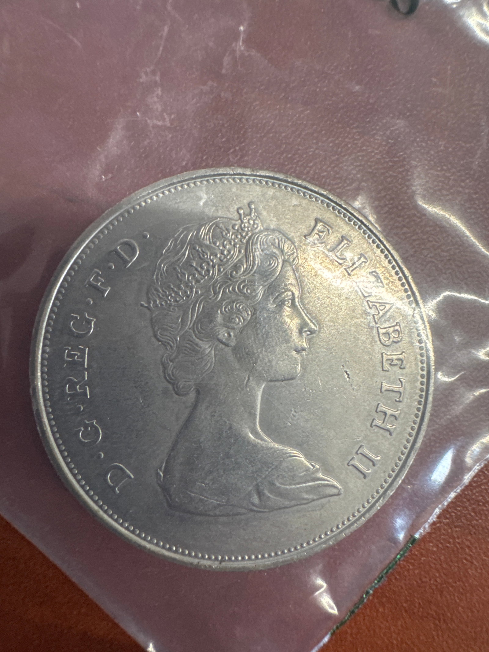 1861 Prince Charles and Lady Diana Spencer Commemorative Coin: A commemorative coin from 1981 featuring the profiles of Prince Charles and Lady Diana Spencer on one side, and Queen Elizabeth II on the other. The coin is silver in color and appears to be in good c