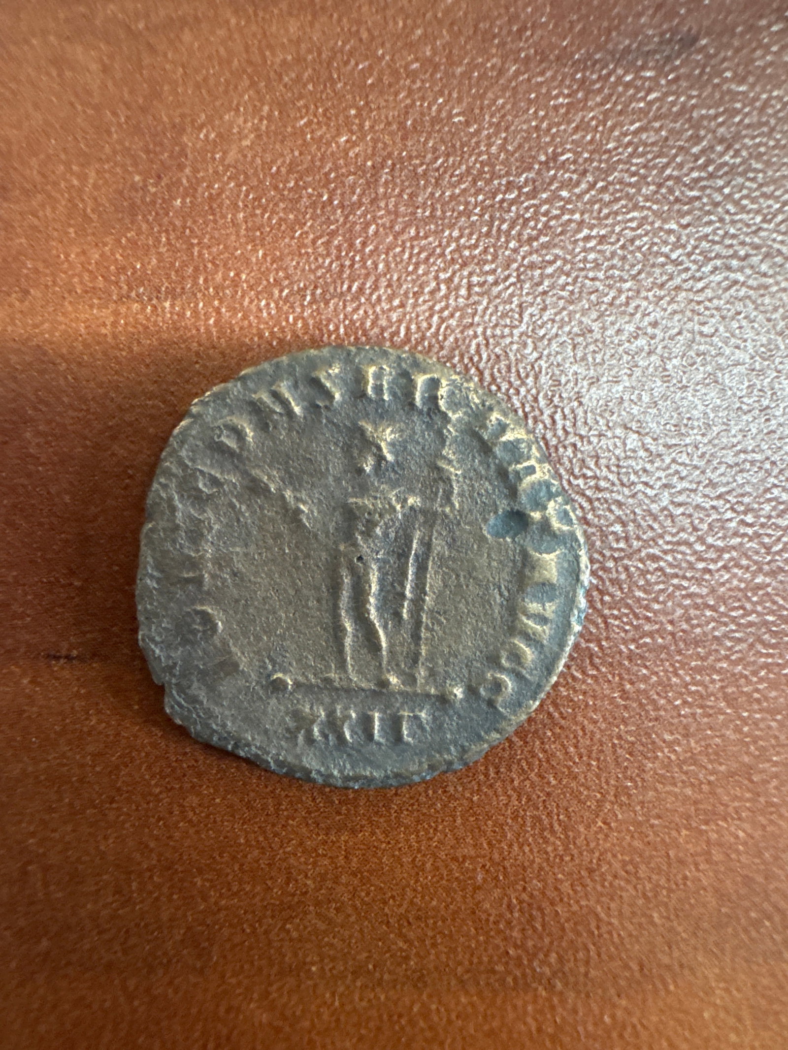 3rd Century Roman Antoninianus Coin: A bronze ancient Roman coin, likely an Antoninianus from the 3rd century. One side features a profile of an emperor, while the reverse depicts a standing figure. The coin exhibits wear and patina cons