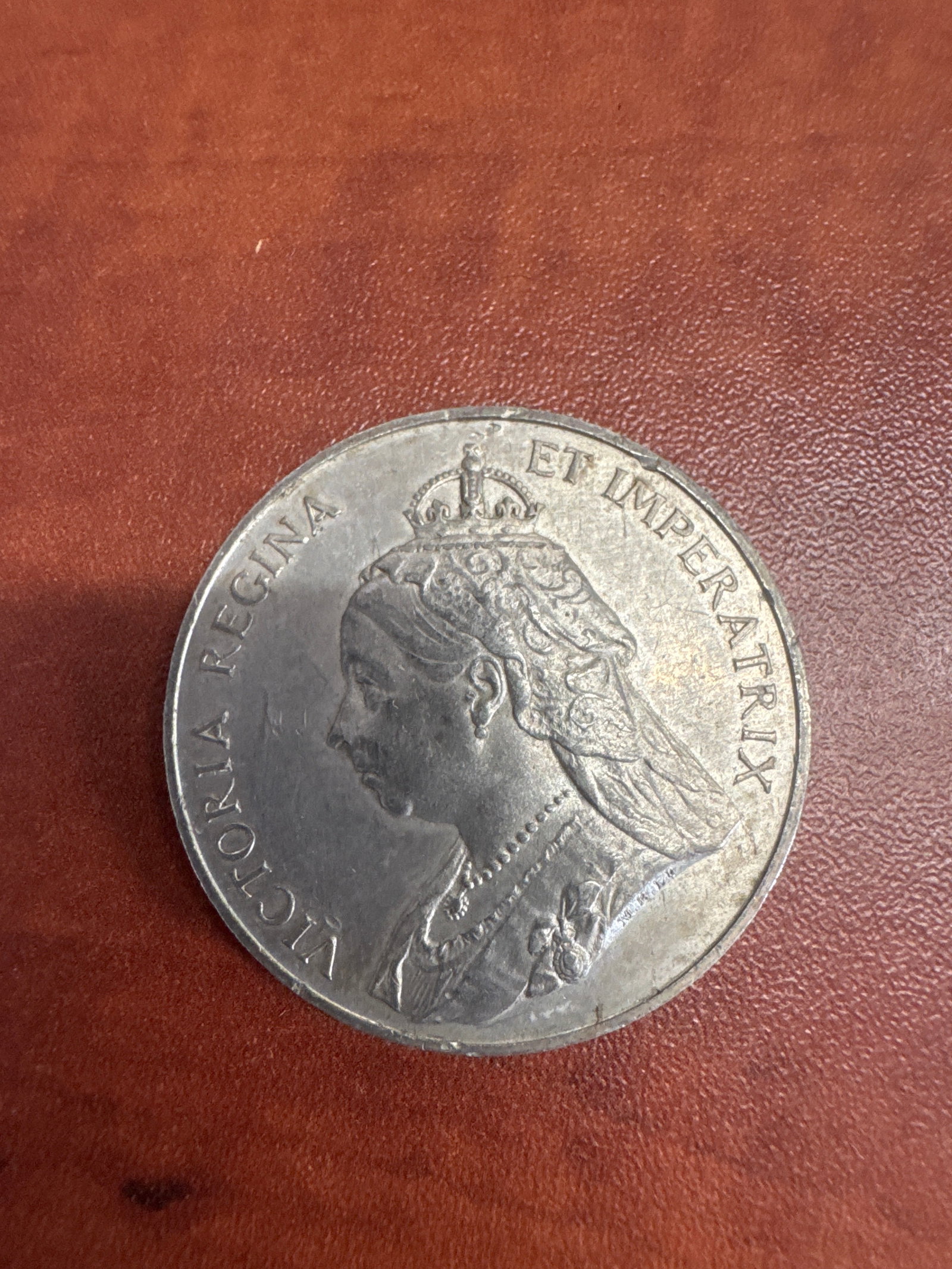 Commemorative Coin for Queen Victoria's Diamond Jubilee (1837-1897): A commemorative coin celebrating Queen Victoria's Diamond Jubilee, featuring her effigy on one side with the inscription 'VICTORIA REG. ET IMP. ER.' and the royal crest with the dates '