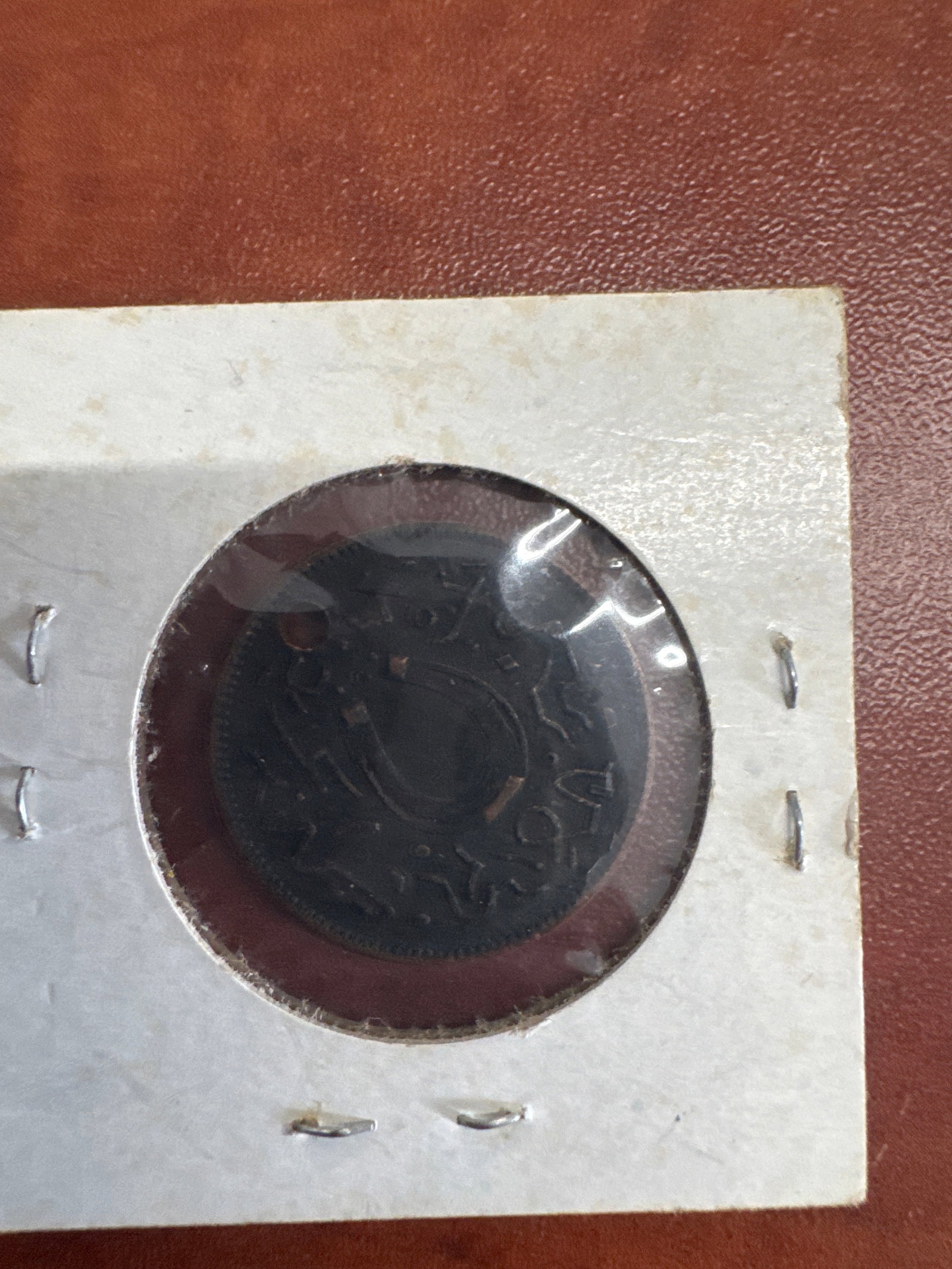 Boston Trade Token, White Bros. & Co., Willow Calf: A vintage Boston Trade Token from White Bros. & Co. in Willow Calf. The token is housed in a protective sleeve within a card mount. The inscription on the token is partially visible, indicating &#
