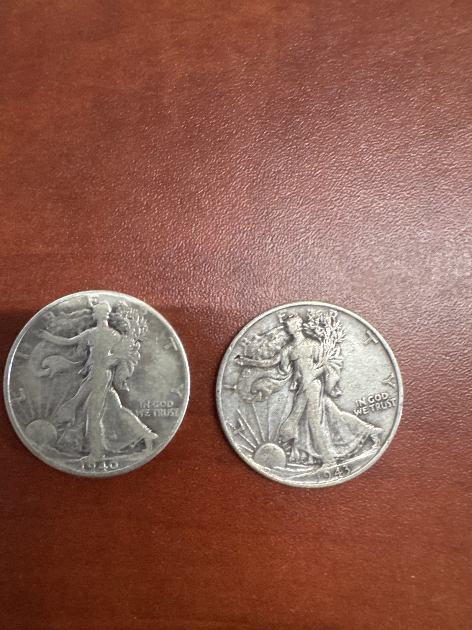 Two Walking Liberty Half Dollar Coins - 1940 and 1943: This lot features two Walking Liberty Half Dollar coins. One coin is dated 1940, and the other is dated 1943. Both coins display the iconic Liberty figure on the obverse and an eagle on the reverse, c