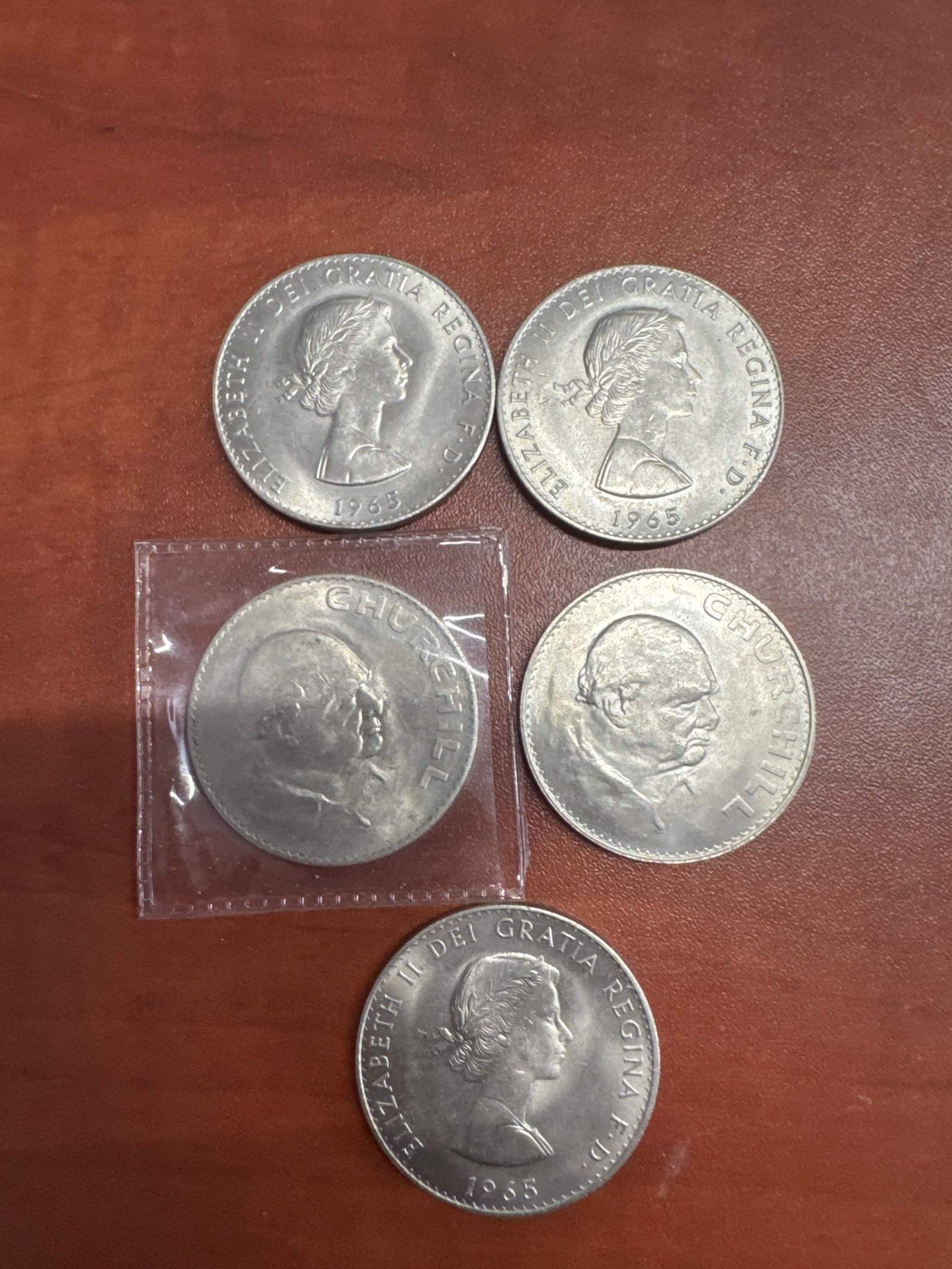 Collection of 1965 Elizabeth II and Winston Churchill Coins: This lot features 5 coins. Depicting Queen Elizabeth II and are dated 1965 and a portrait of Winston Churchill. 