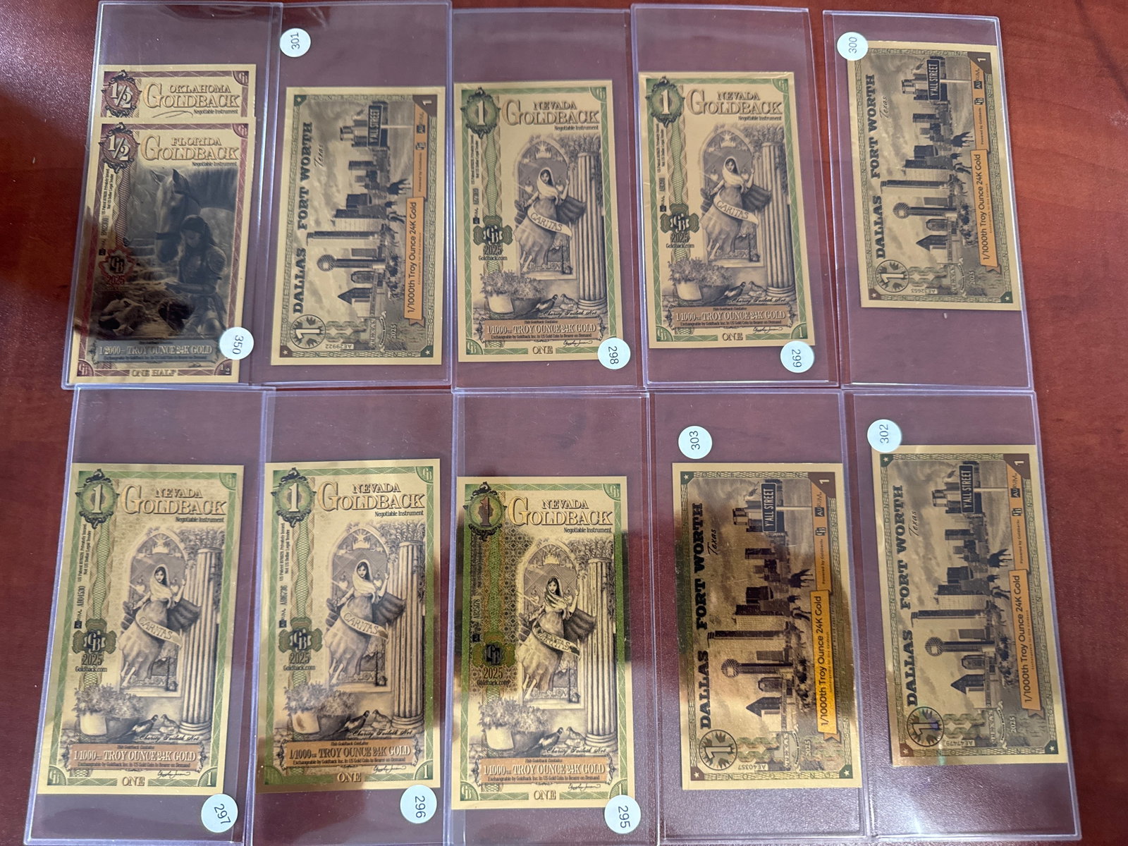 Collection of 10 Goldback Notes: This lot features a collection of ten Goldback notes, each representing a unique design and denomination. The notes are encased in protective sleeves, showcasing intricate details and the lustrous gol