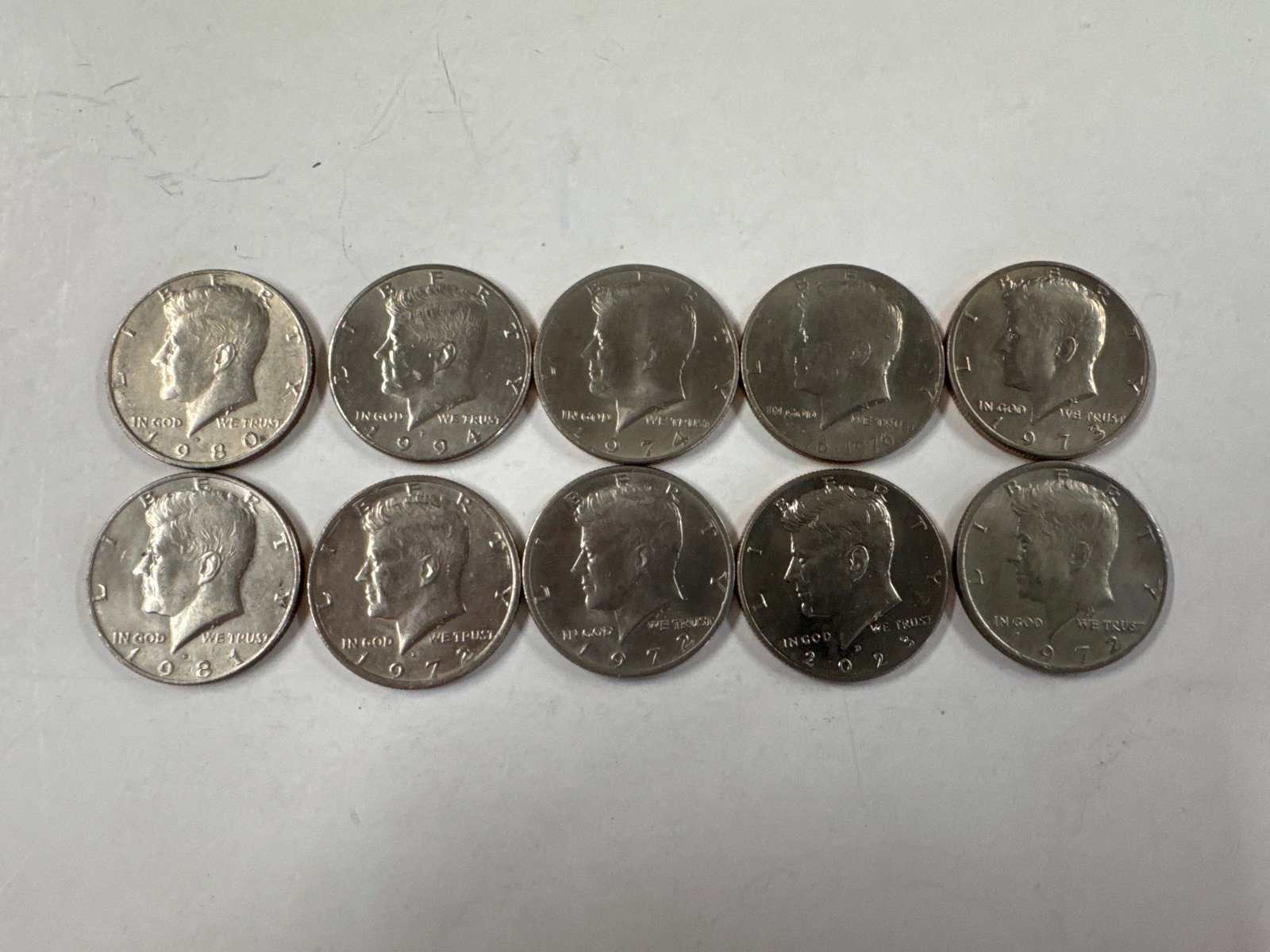 Collection of 10 Kennedy Half Dollar Coins: This lot features a collection of ten Kennedy Half Dollar coins. The obverse displays the profile of John F. Kennedy, while the reverse shows the Presidential Seal. 